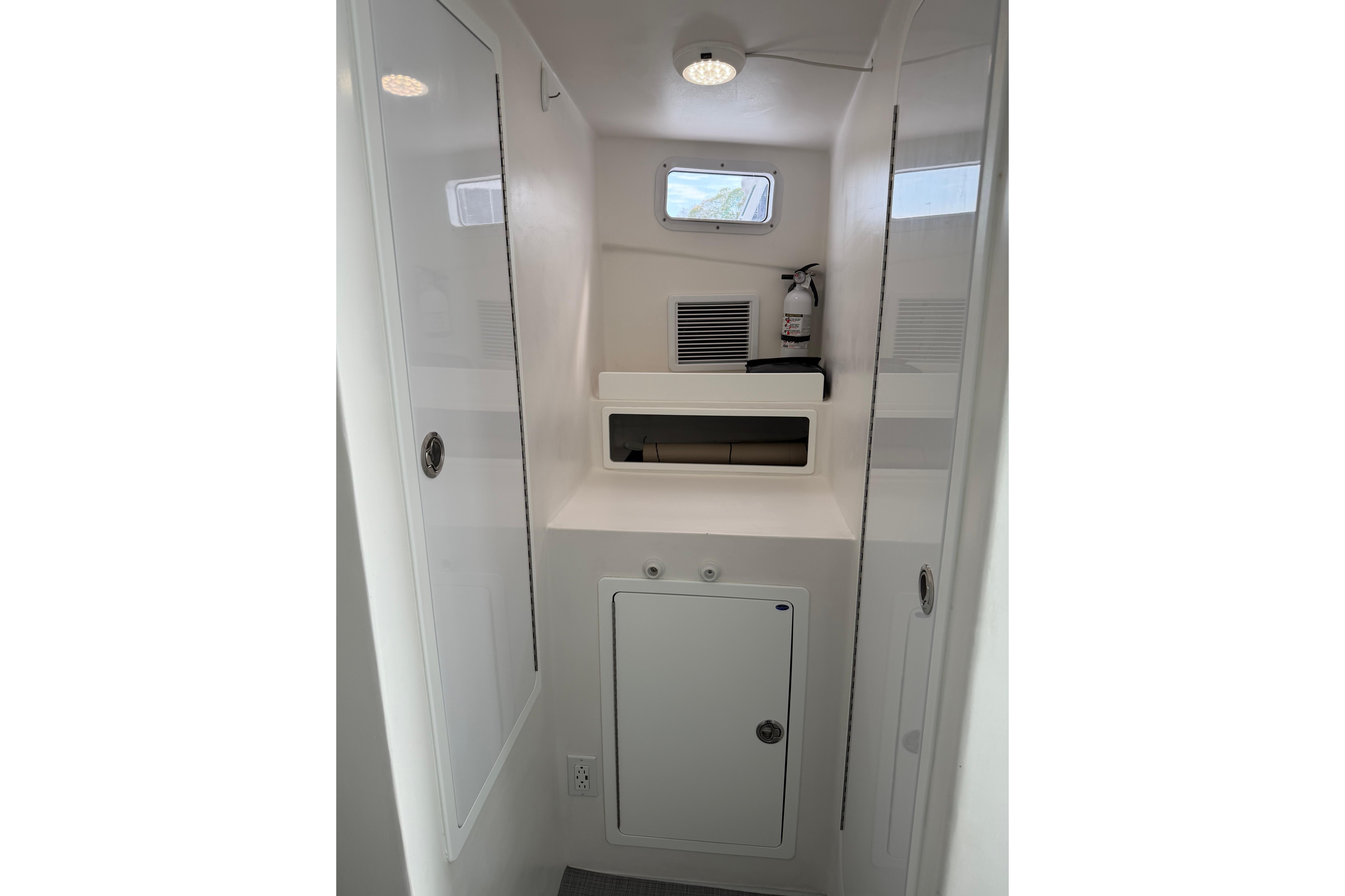 Interior of 2018 H&H Marine Osmond Beal boat, featuring storage compartments and a fire extinguisher.