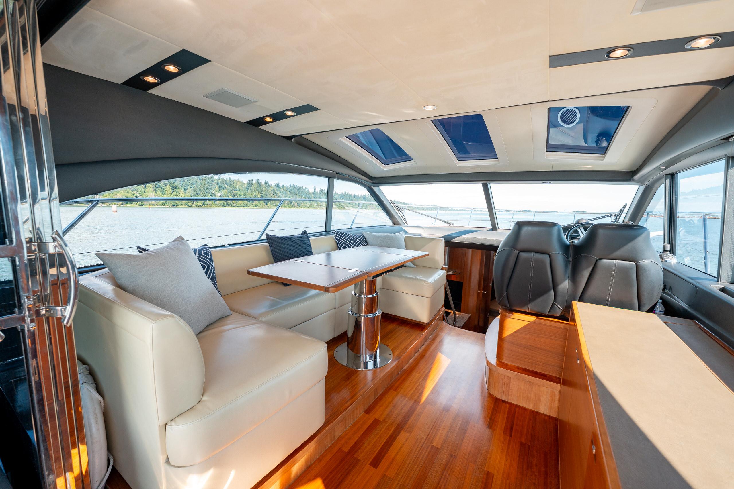 Luxurious interior of 2015 Princess V48 yacht with leather seating and panoramic windows.