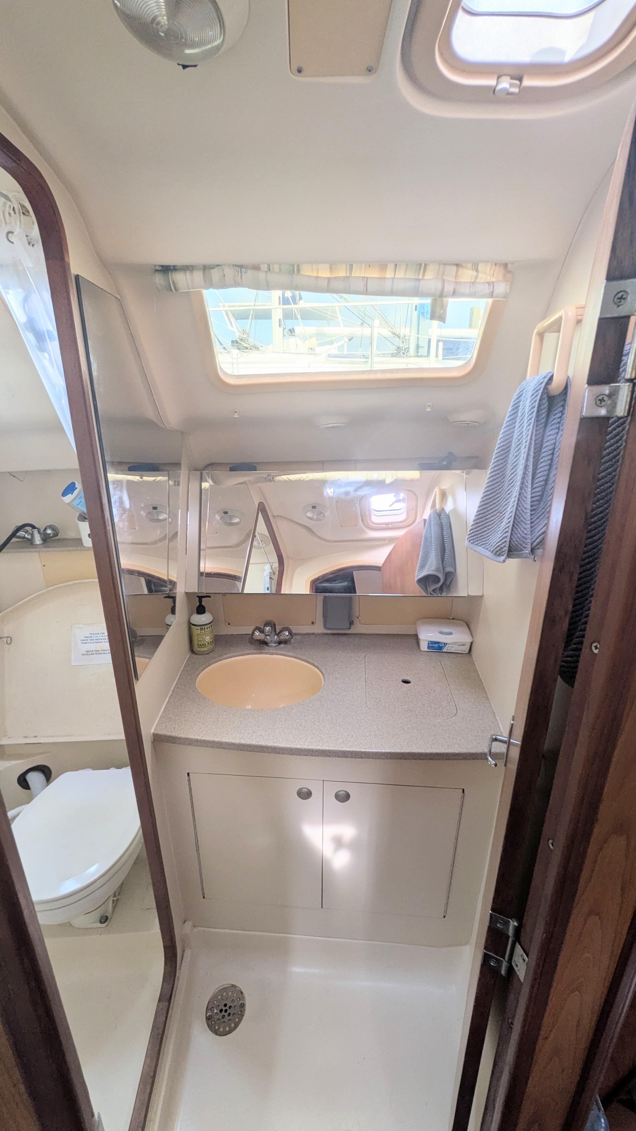 2001 Hunter 380 yacht bathroom with sink, mirror, and skylight.