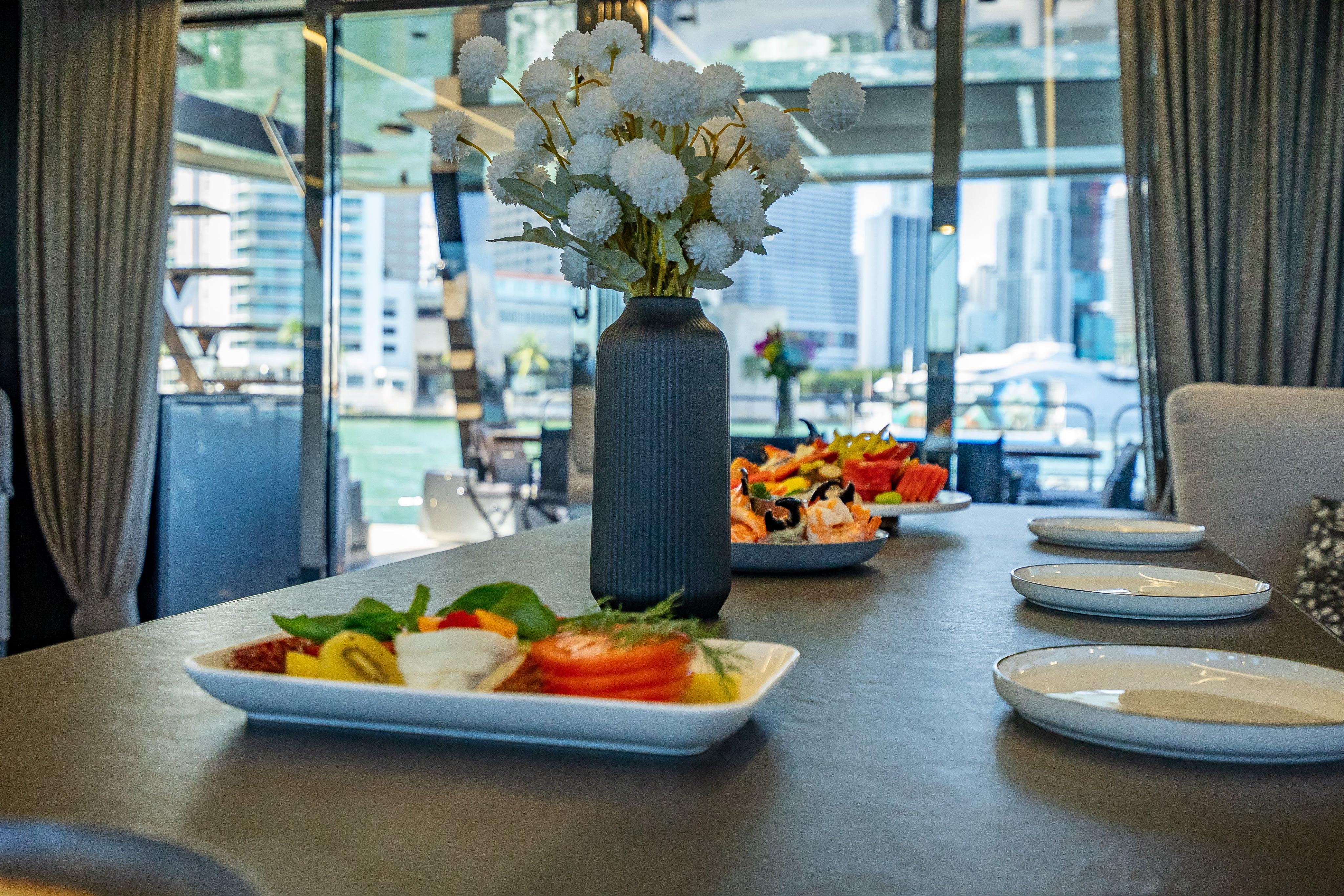 Luxurious dining setup on 2026 Sunreef 60 Power yacht with cityscape view.