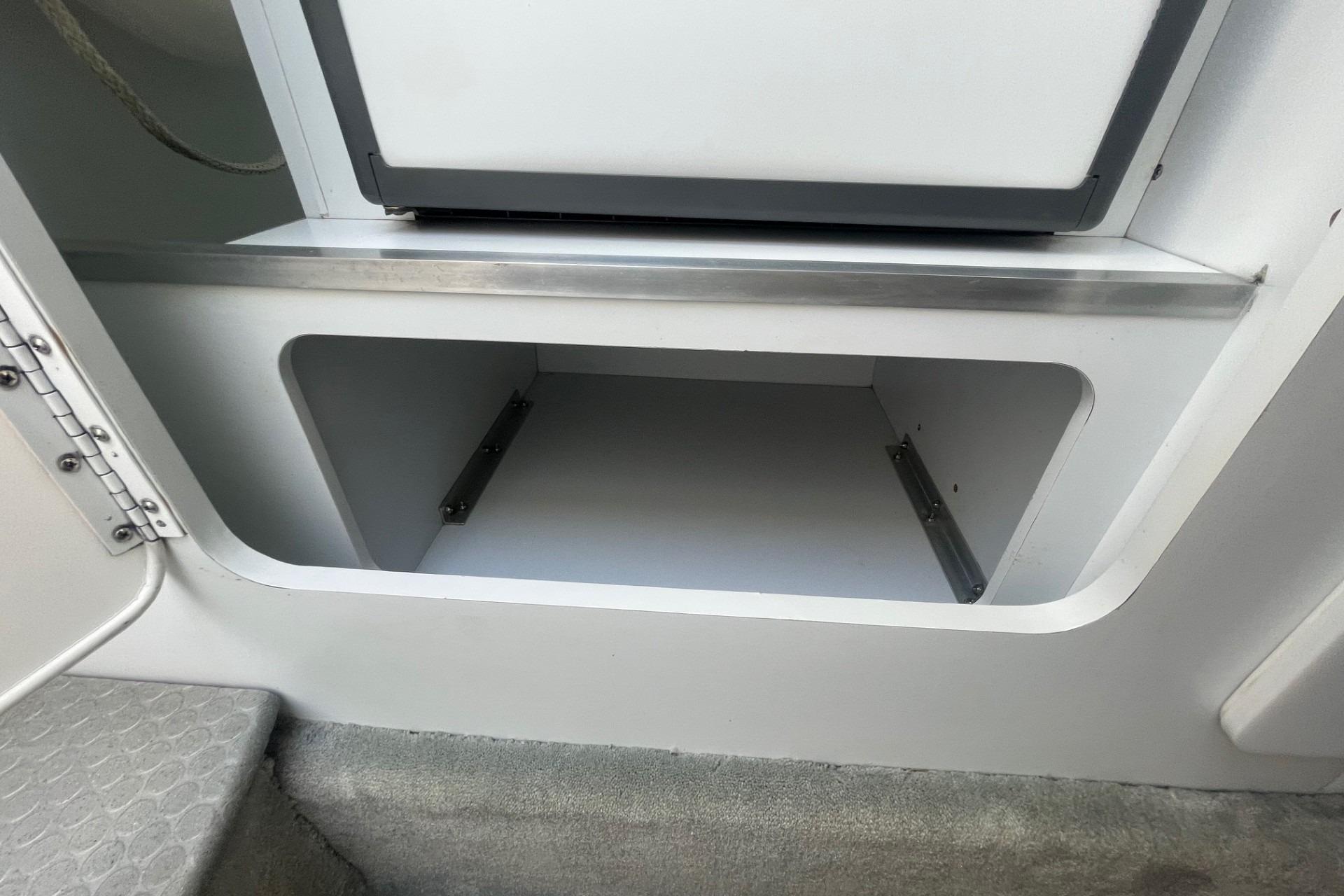 Open storage compartment in a 2004 Formula 382 FASTech boat interior.
