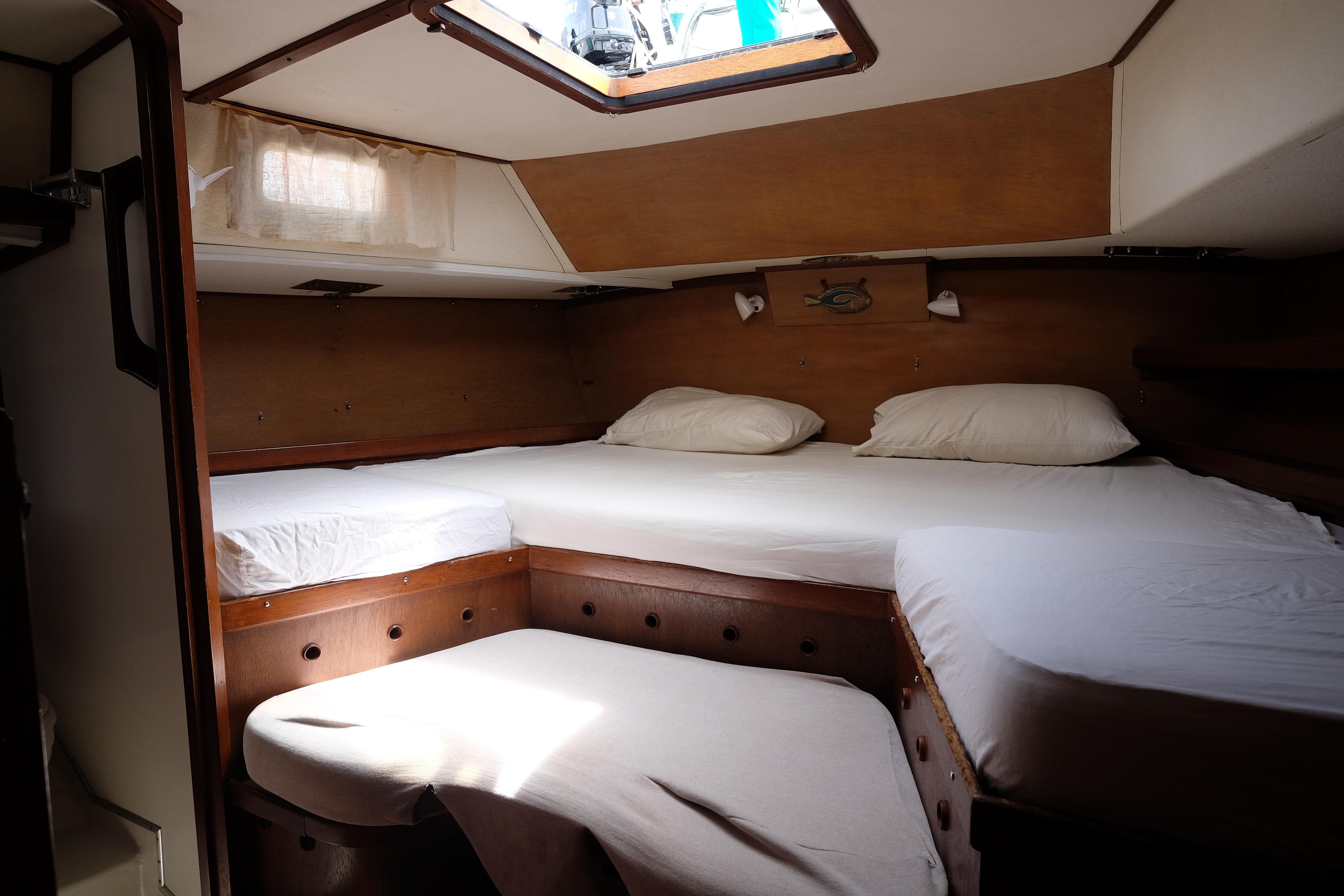 Cozy cabin interior of a 1979 Bruce Roberts 44 sailboat with a comfortable bed setup.