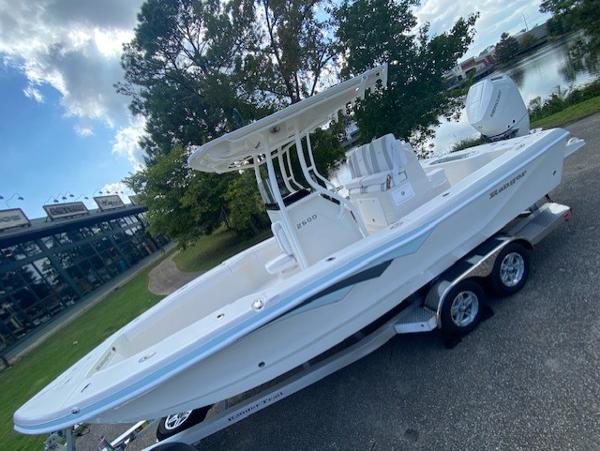 2024 Ranger 2600 Bay boat on trailer, parked near water and trees.