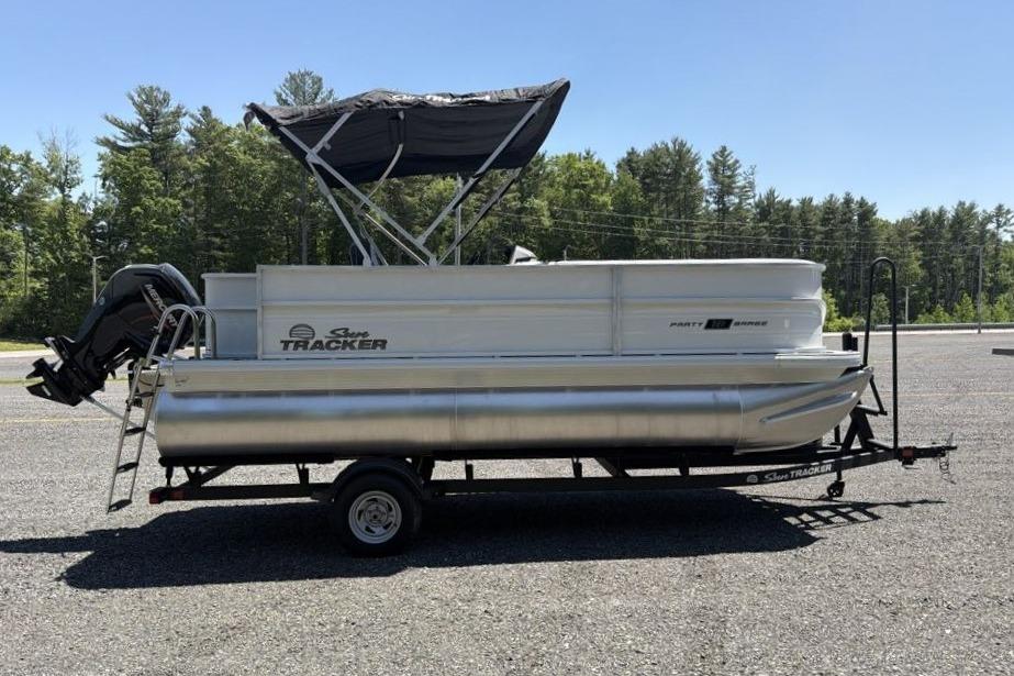 2026 Sun Tracker Party Barge 18 DLX pontoon boat on trailer, parked outdoors.