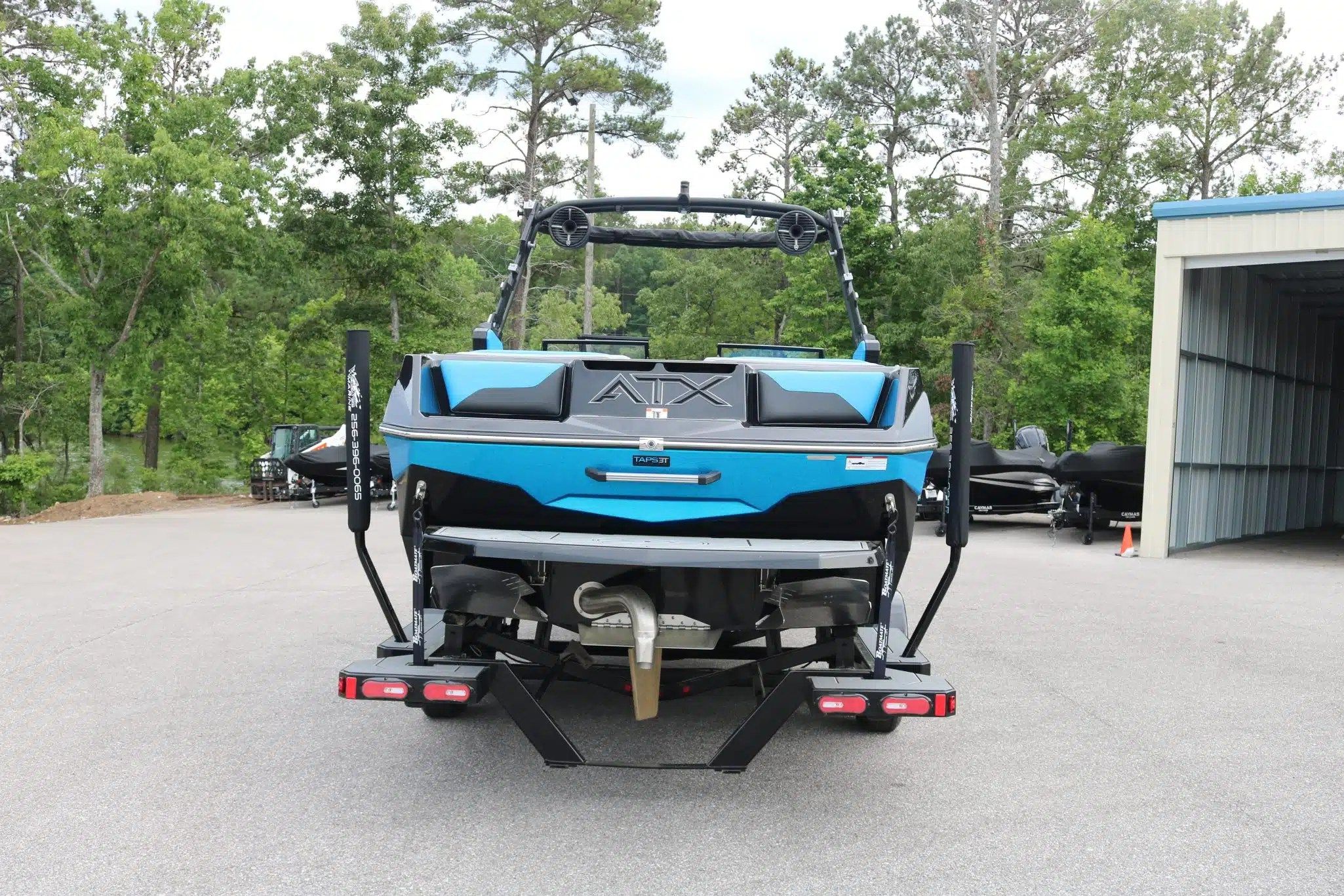 Rear view of blue 2024 ATX Surf Boats 24 Type-S on trailer.