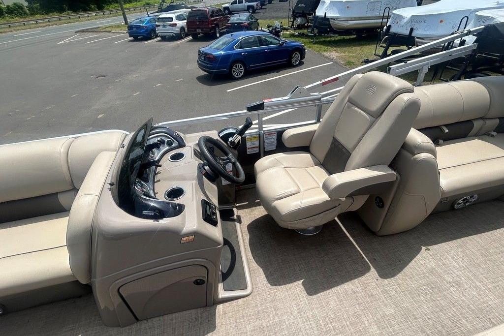 2023 Sun Tracker Party Barge 22 DLX interior with beige seating and steering console.