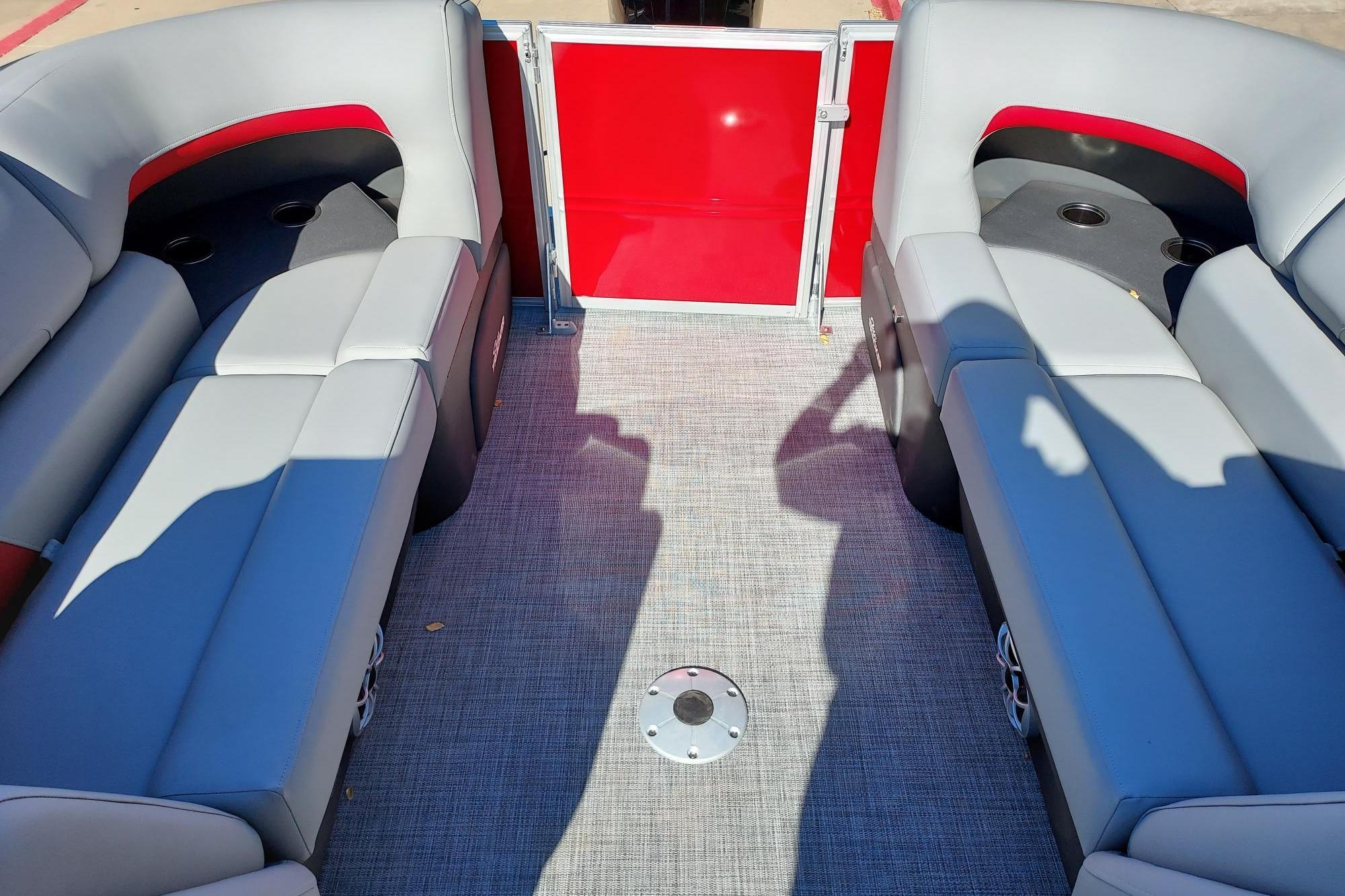 2026 Sun Tracker Party Barge 22 DLX interior with gray seating and red accents.