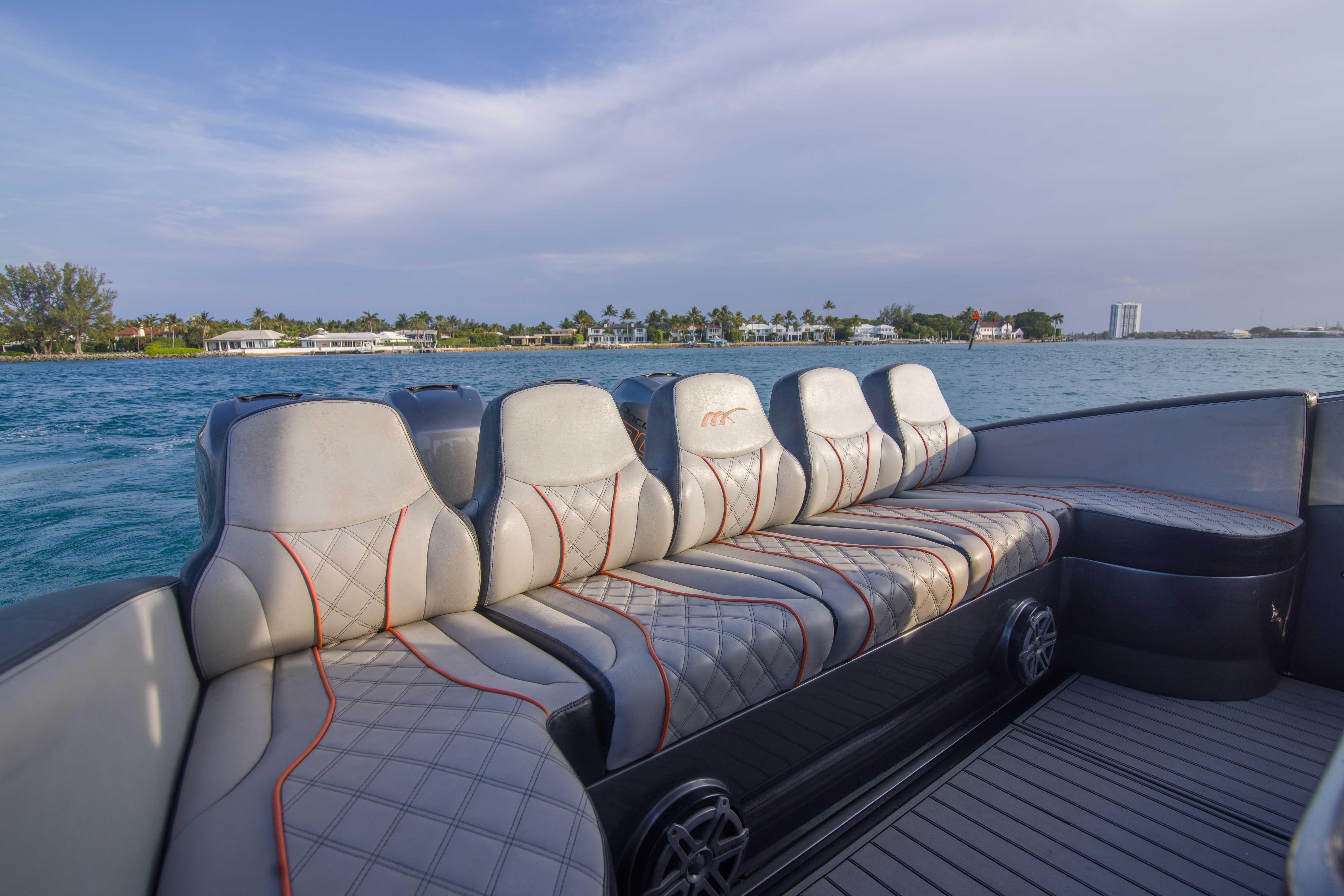 Luxurious seating on a 2019 Midnight Express 43 Open boat, cruising near a scenic coastline.