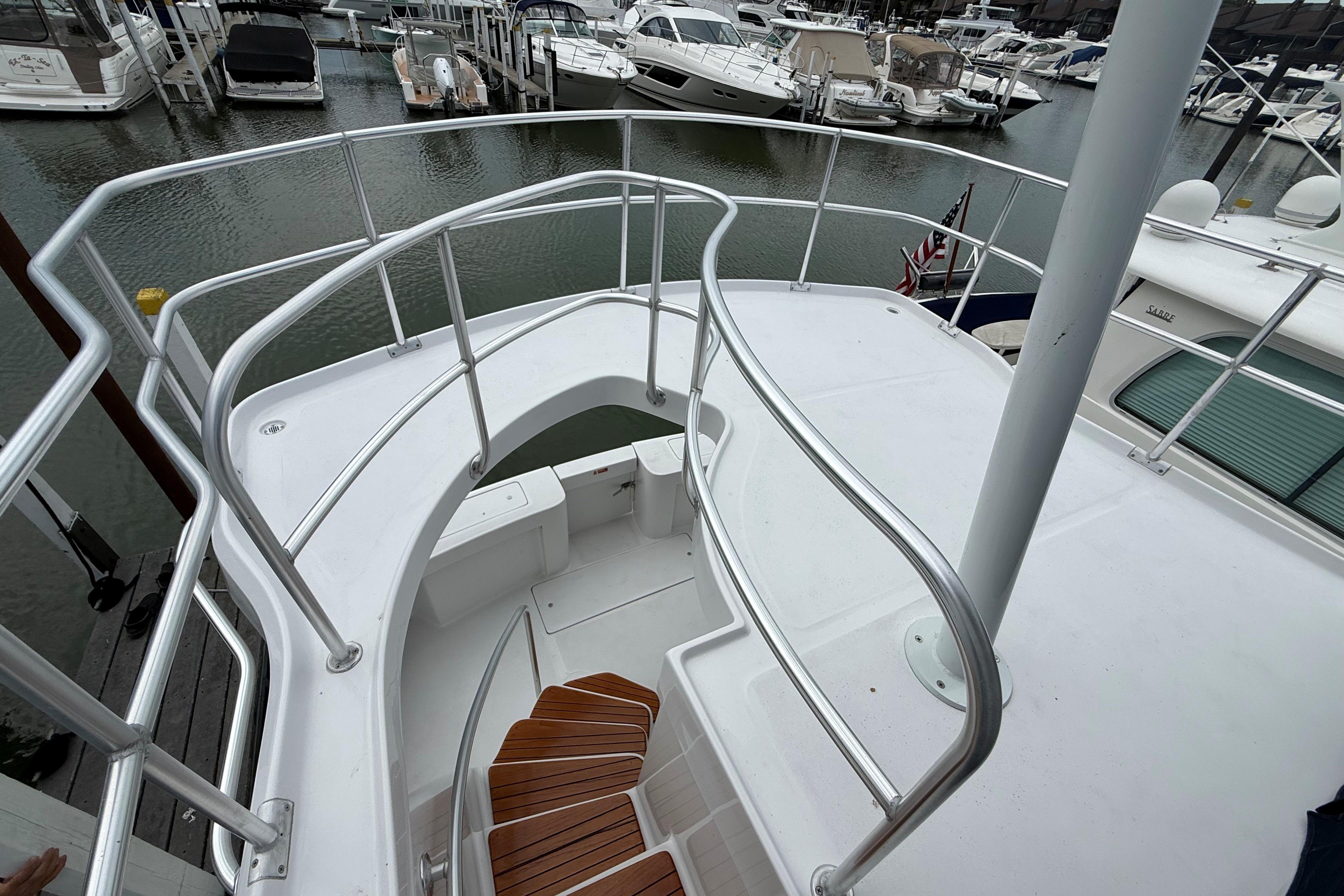 1999 Mainship 350 Trawler deck with railing, docked at marina.