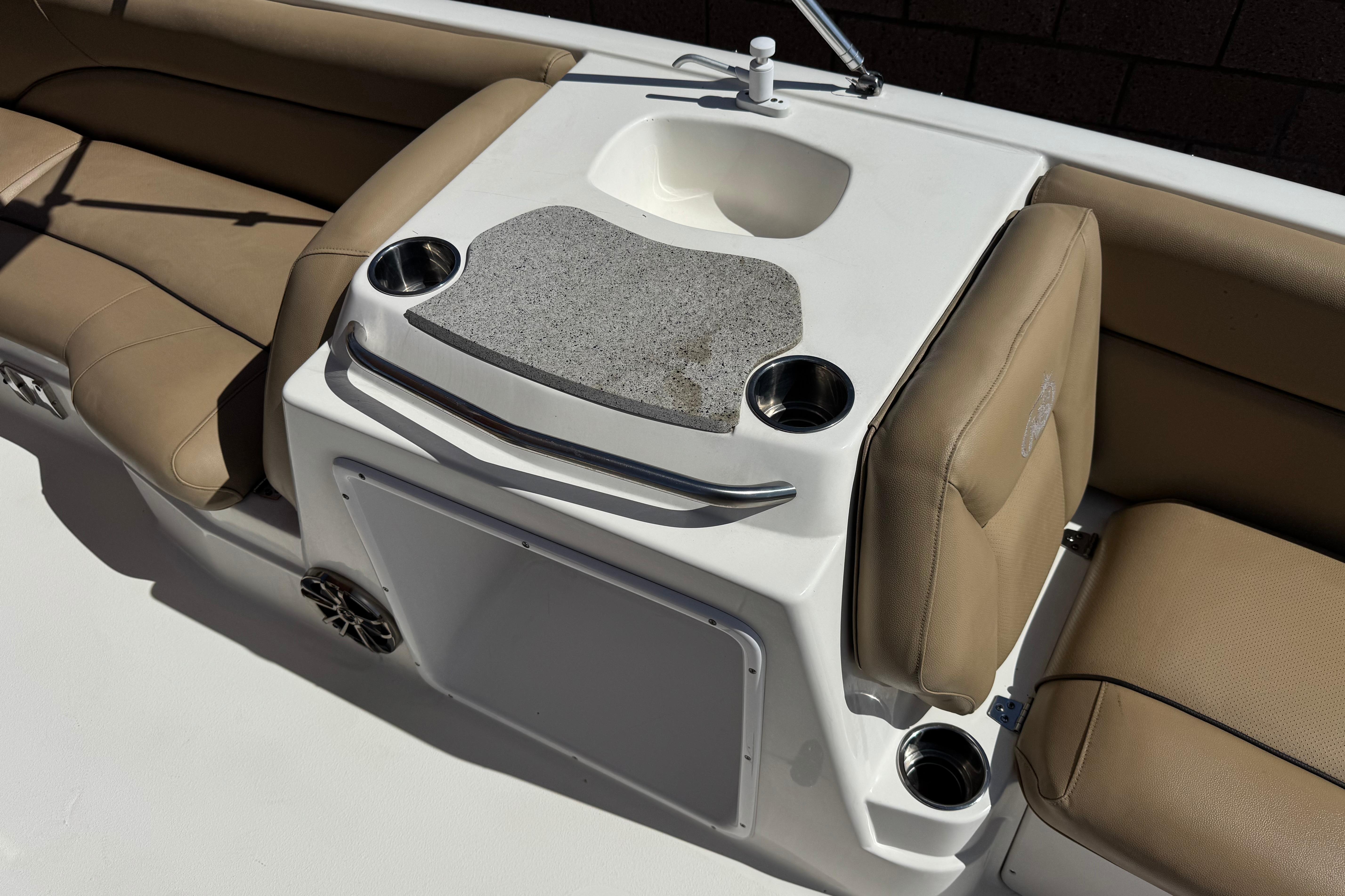 2020 NauticStar 203 SC boat interior with beige seating and a built-in sink.