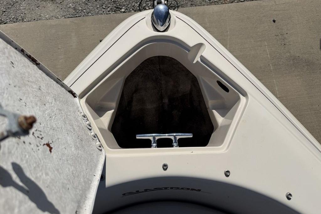 1999 Glastron GT 225 boat bow with open storage compartment and cleat.