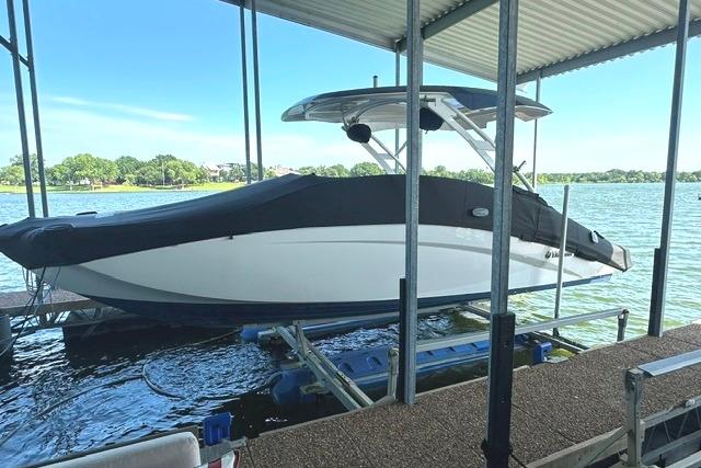 2021 Yamaha Boats 275SD docked under a covered marina on a sunny day.