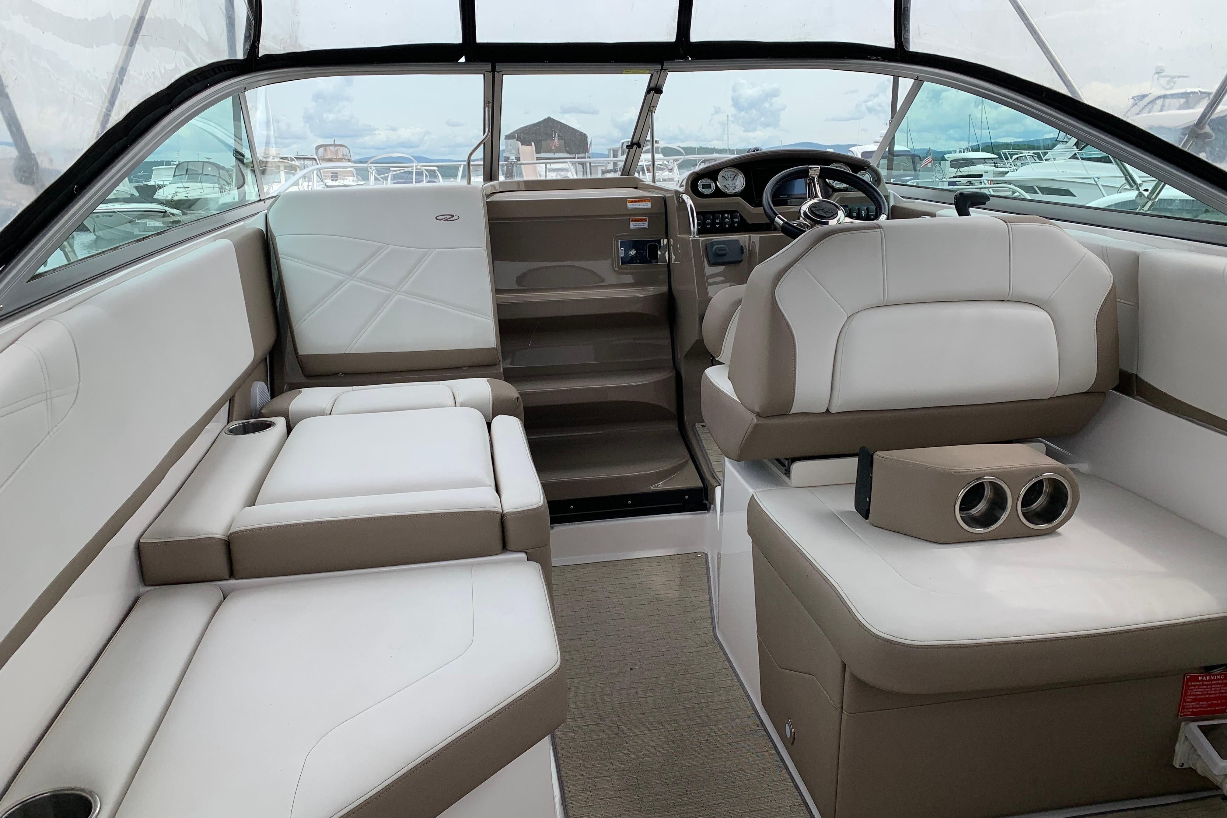 2017 Regal 26 Express boat interior with beige and white seating, steering wheel, and dashboard.
