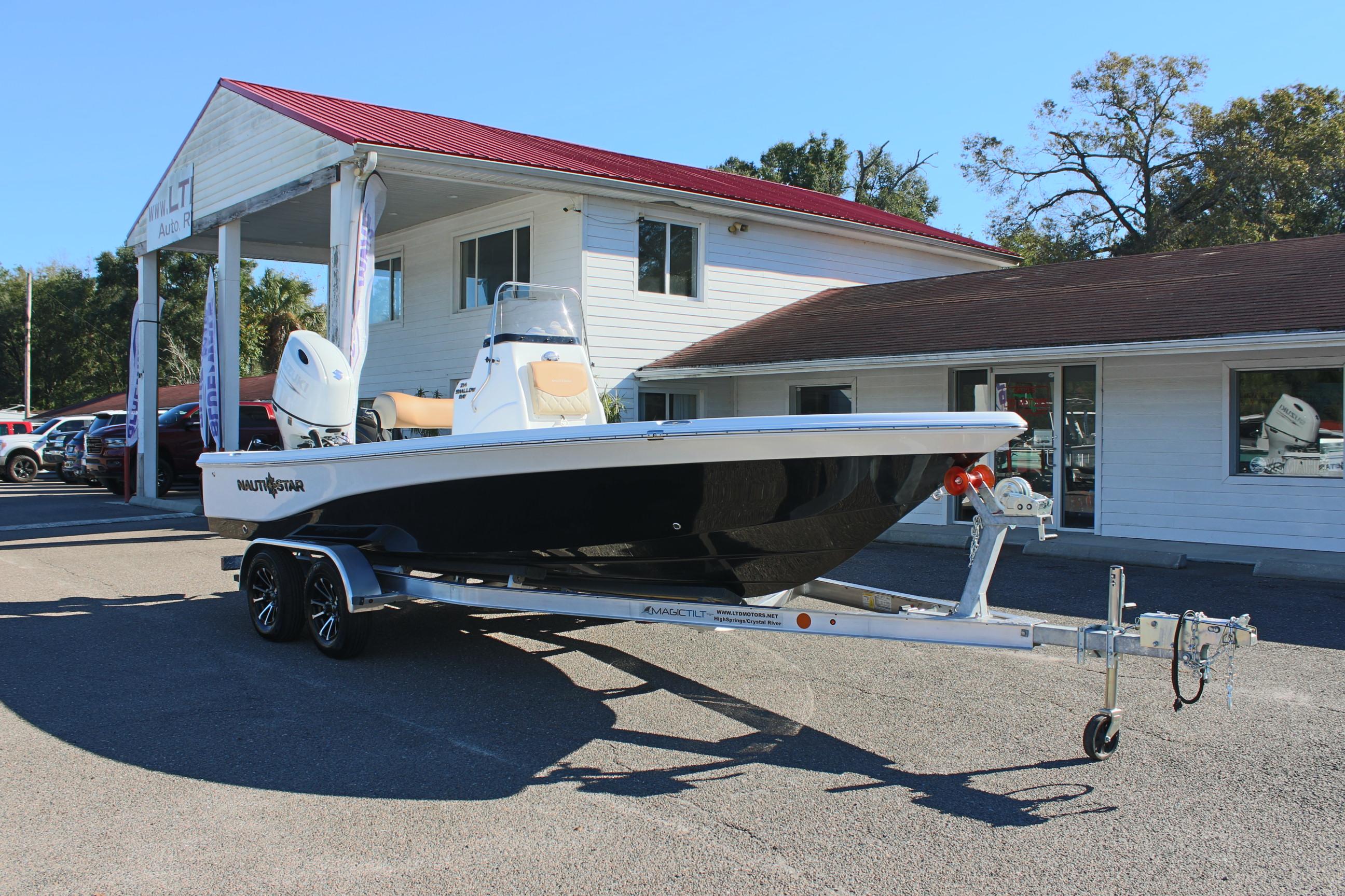 2025 NauticStar 214 Shallow Bay boat on trailer, parked outside a building.