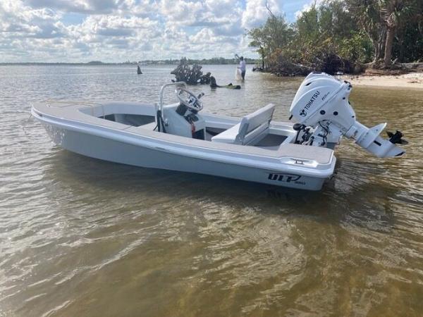 2024 Ultra Lite Tenders ULT 380 boat on calm water near a sandy shore.