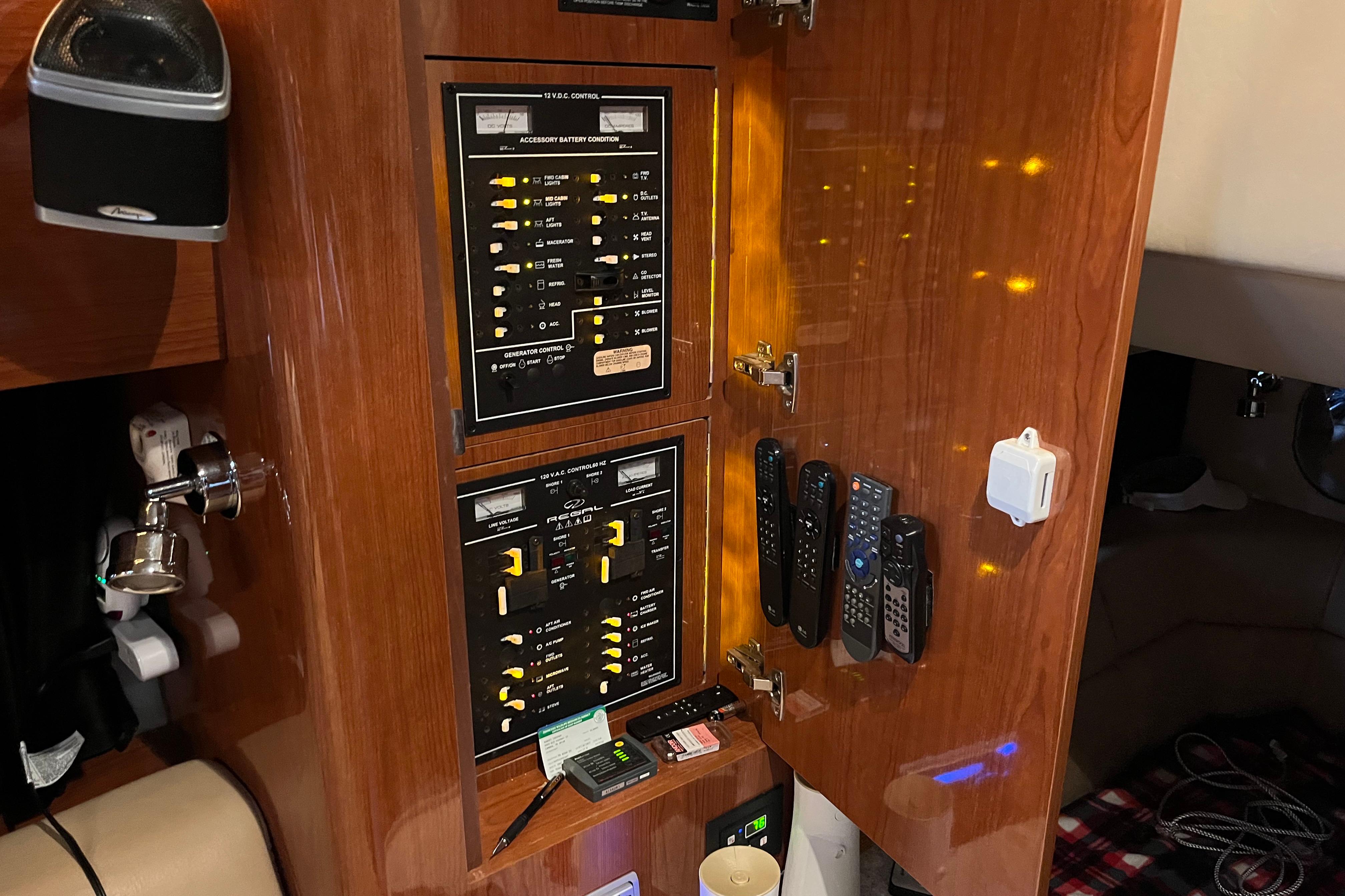 Control panel inside 2007 Regal 3760 IB Commodore yacht with remotes and switches.