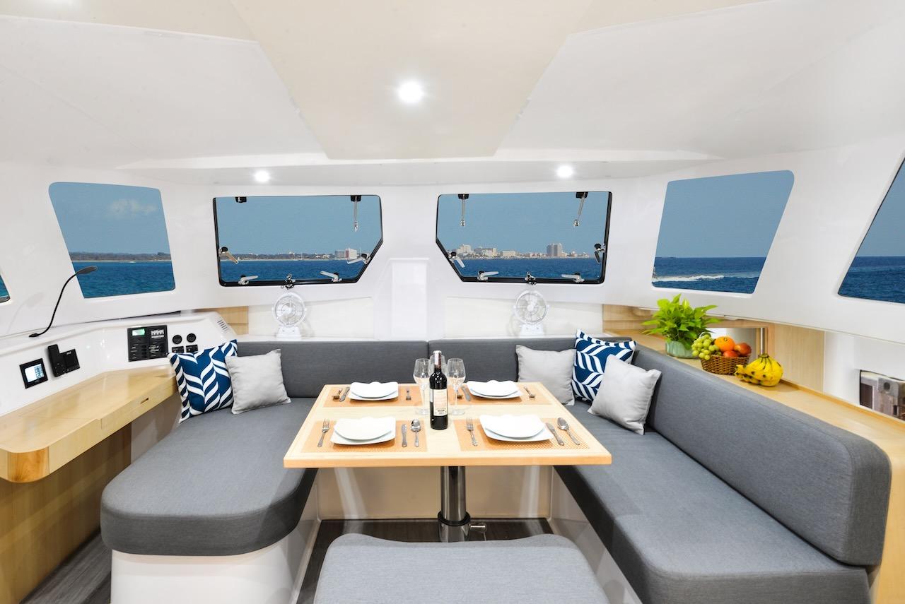 Luxurious interior of 2025 Seawind 1170 catamaran with dining area and ocean view.