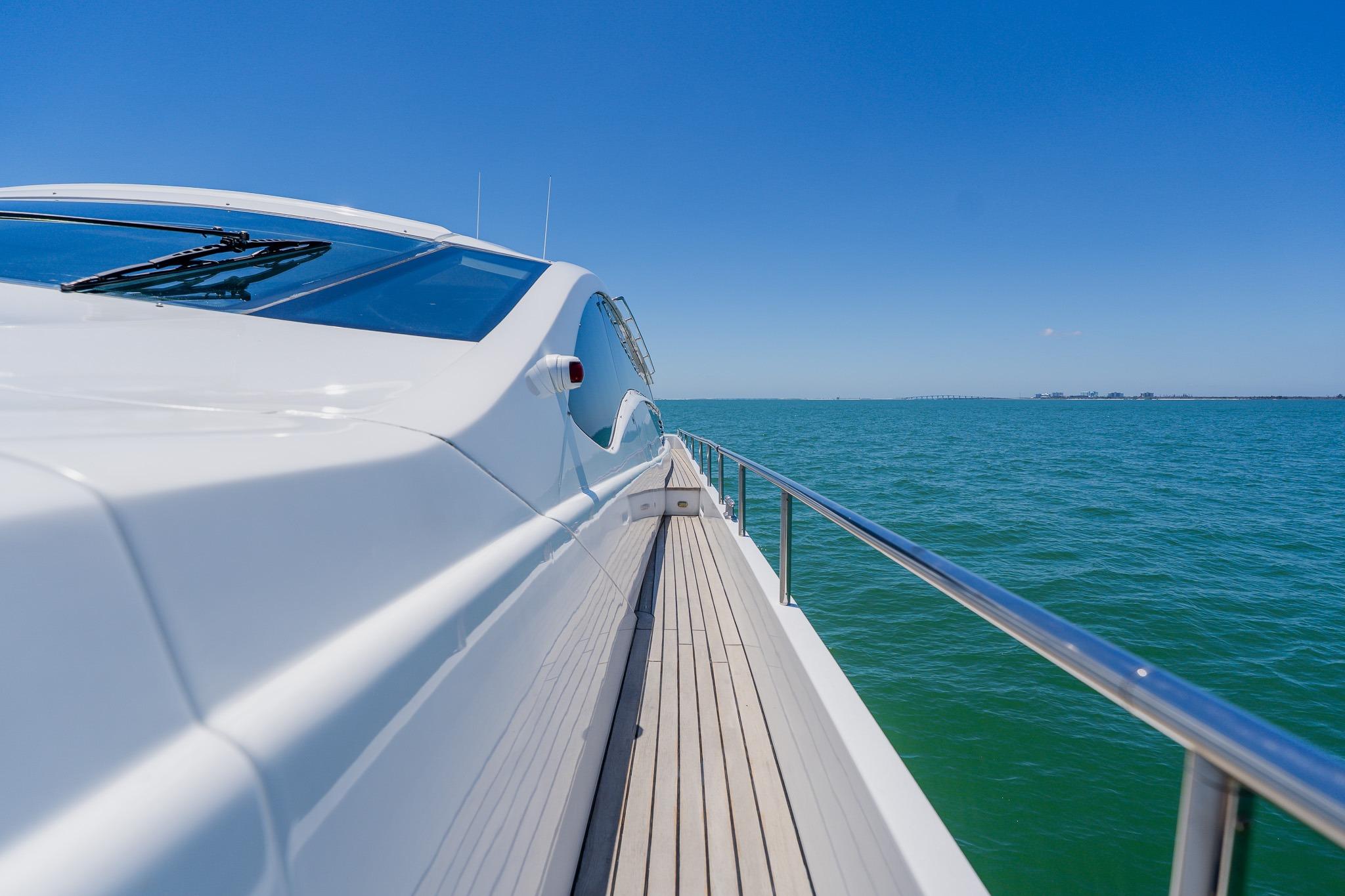 Sleek 2010 Pershing 80 yacht cruising on clear blue ocean under sunny skies.