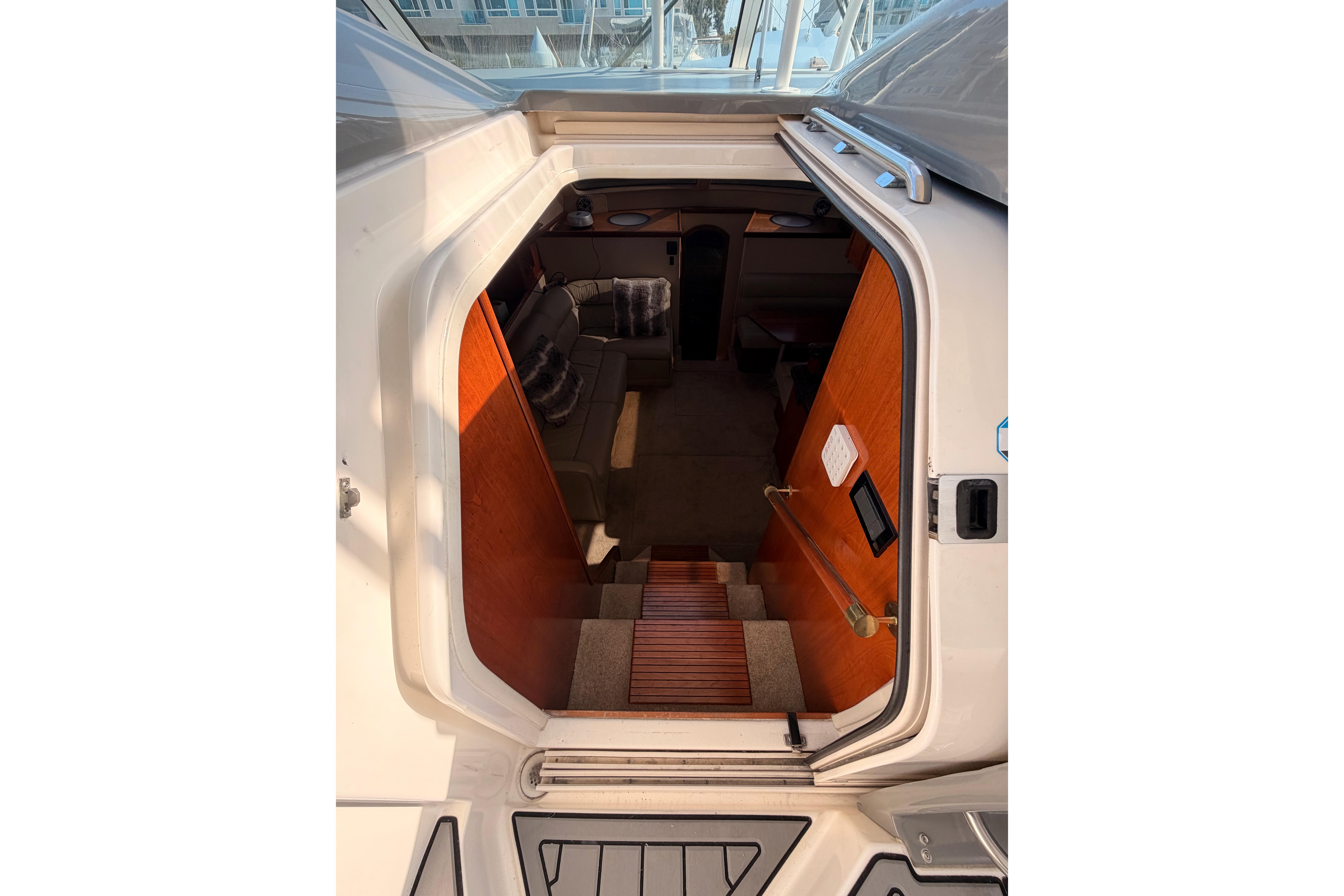 2005 Cruisers Yachts 405 Express Motoryacht interior view with wooden stairs and cozy seating.
