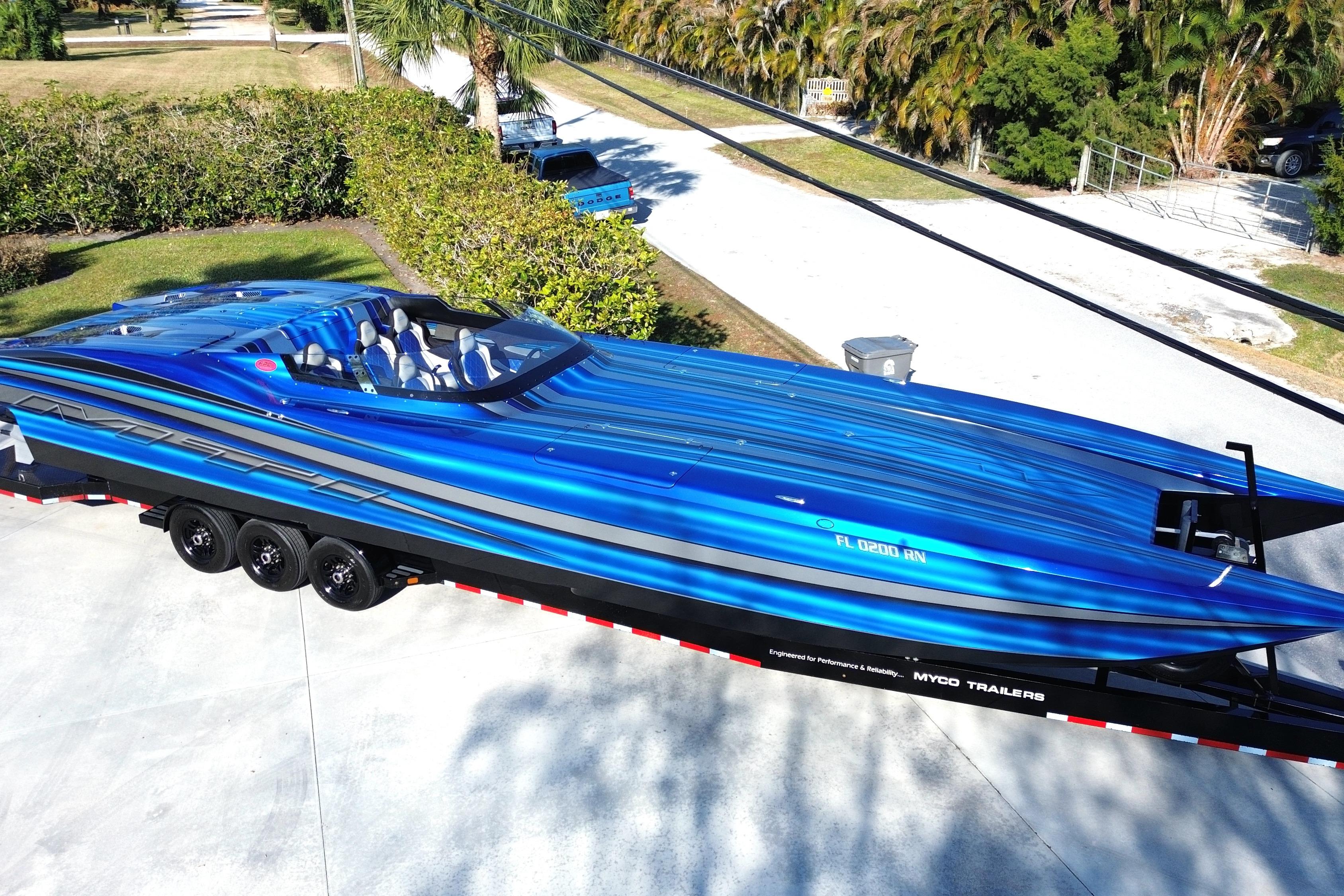 2016 MTI 44 RP speedboat in vibrant blue on a trailer, parked outdoors.