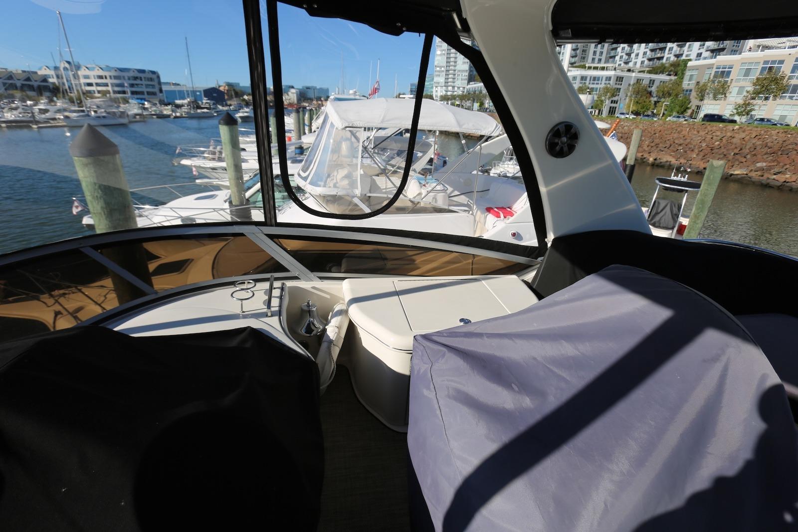 2004 Sea Ray 420 Sedan Bridge interior view at marina, showcasing helm and seating area.