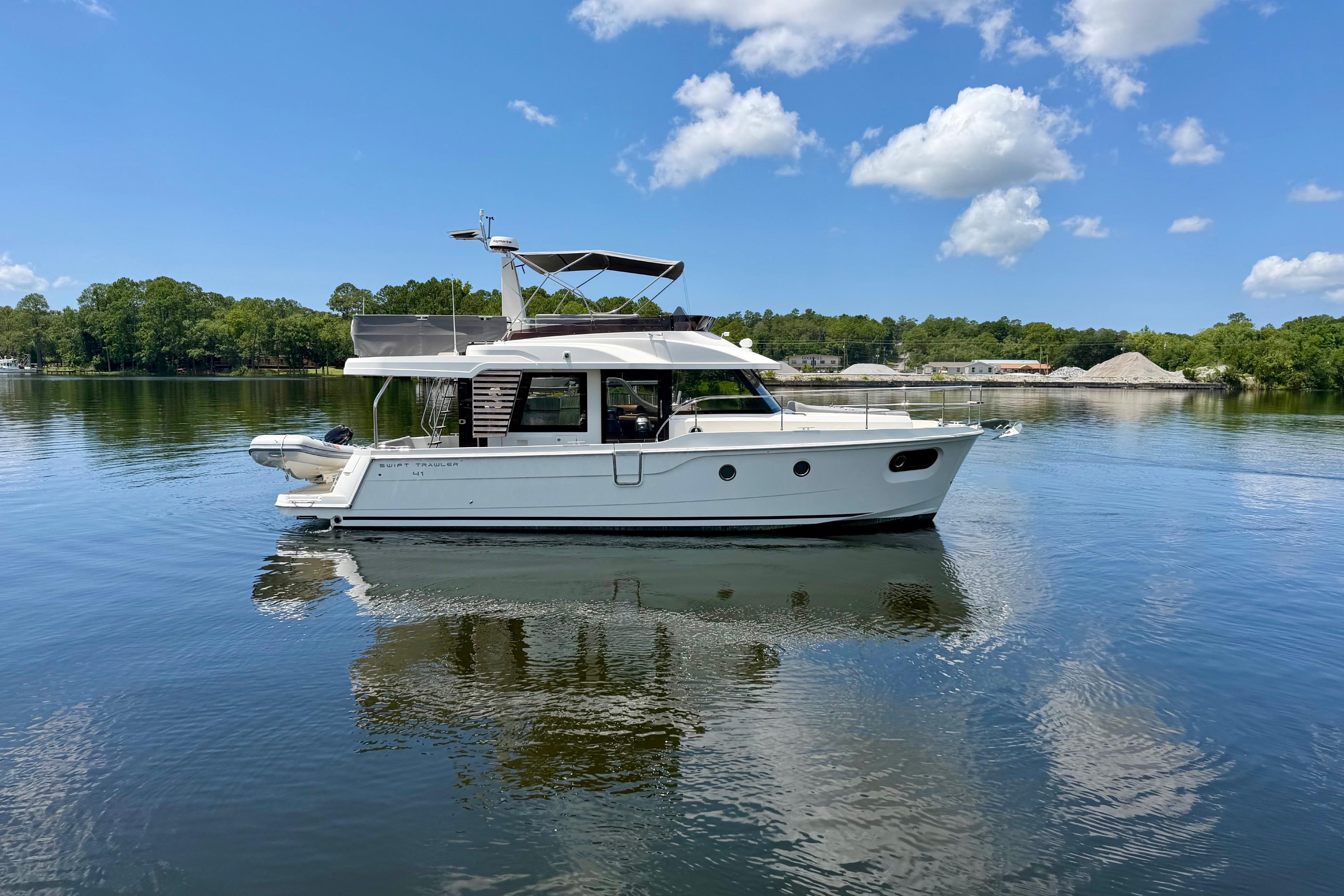 2025 Beneteau Swift Trawler 41 Fly on calm water under blue sky.