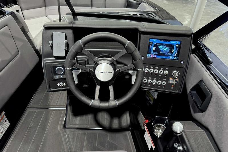 2026 Moomba Max boat dashboard with steering wheel and digital display.