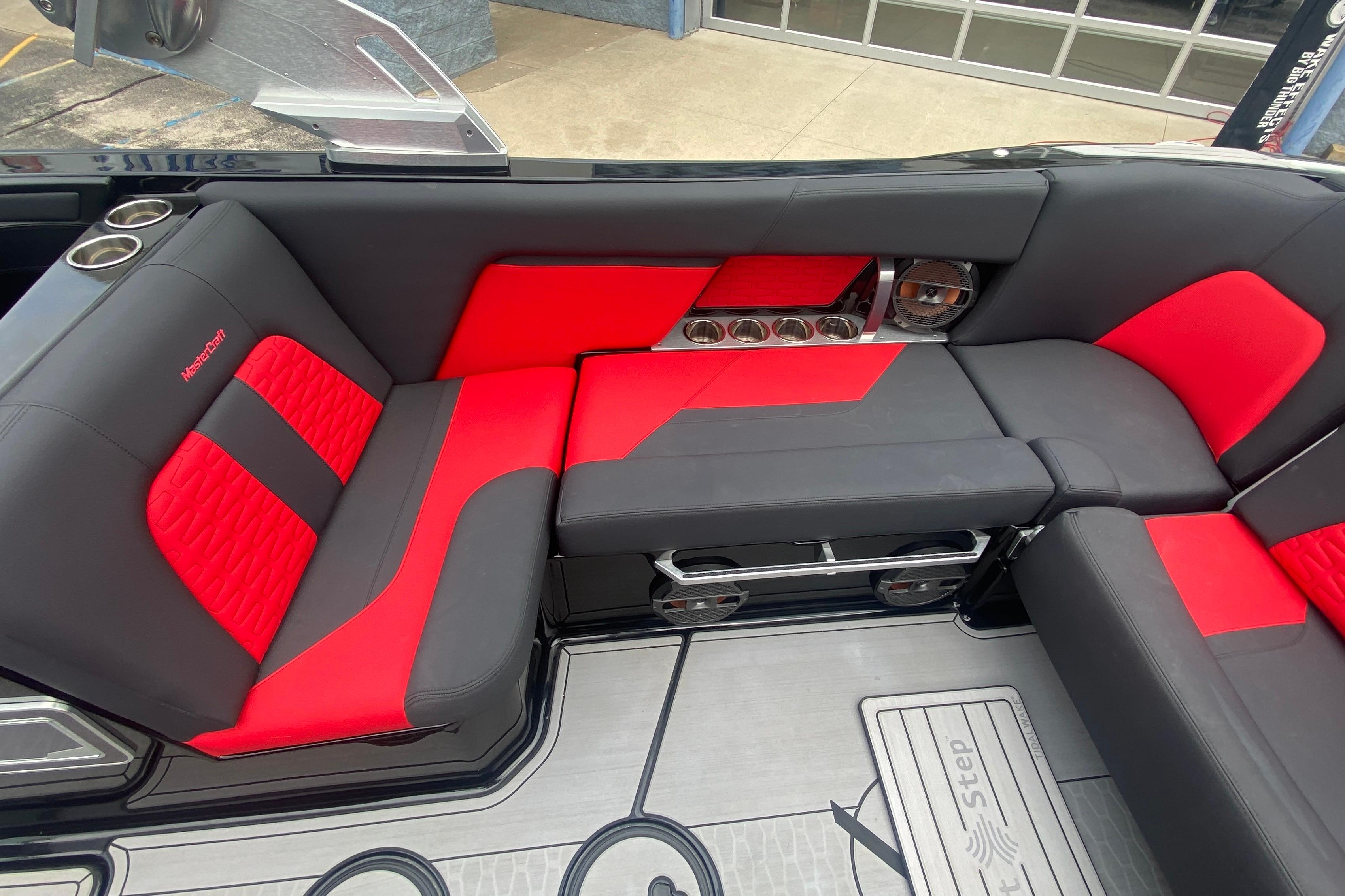 2021 MasterCraft X26 interior with red and black seating, cup holders, and speakers.