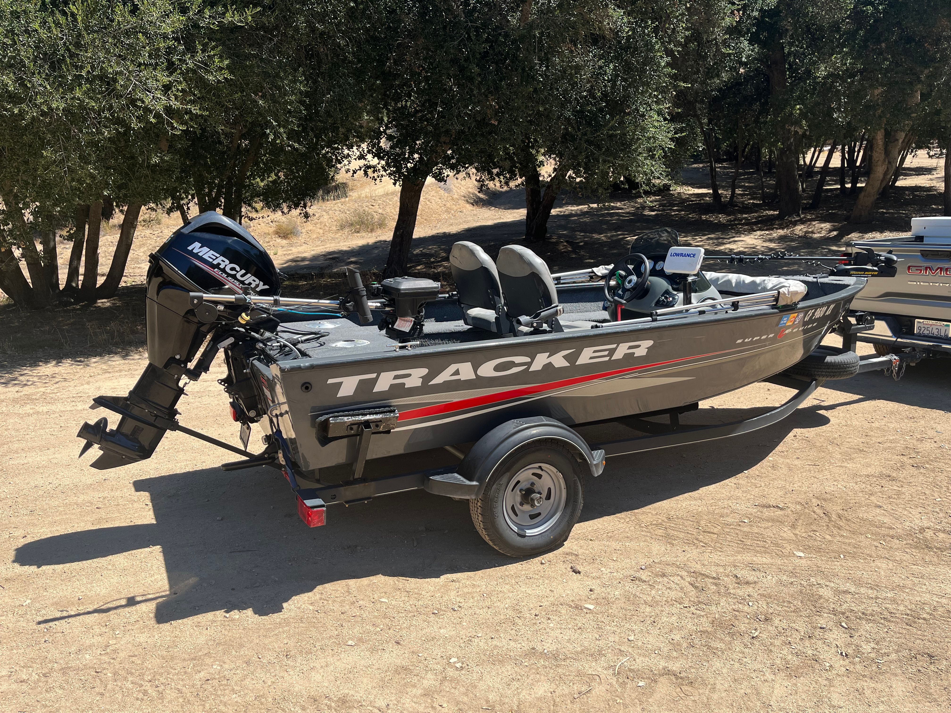 A 2017 Tracker SGV16 SC boat on a trailer in a wooded area.