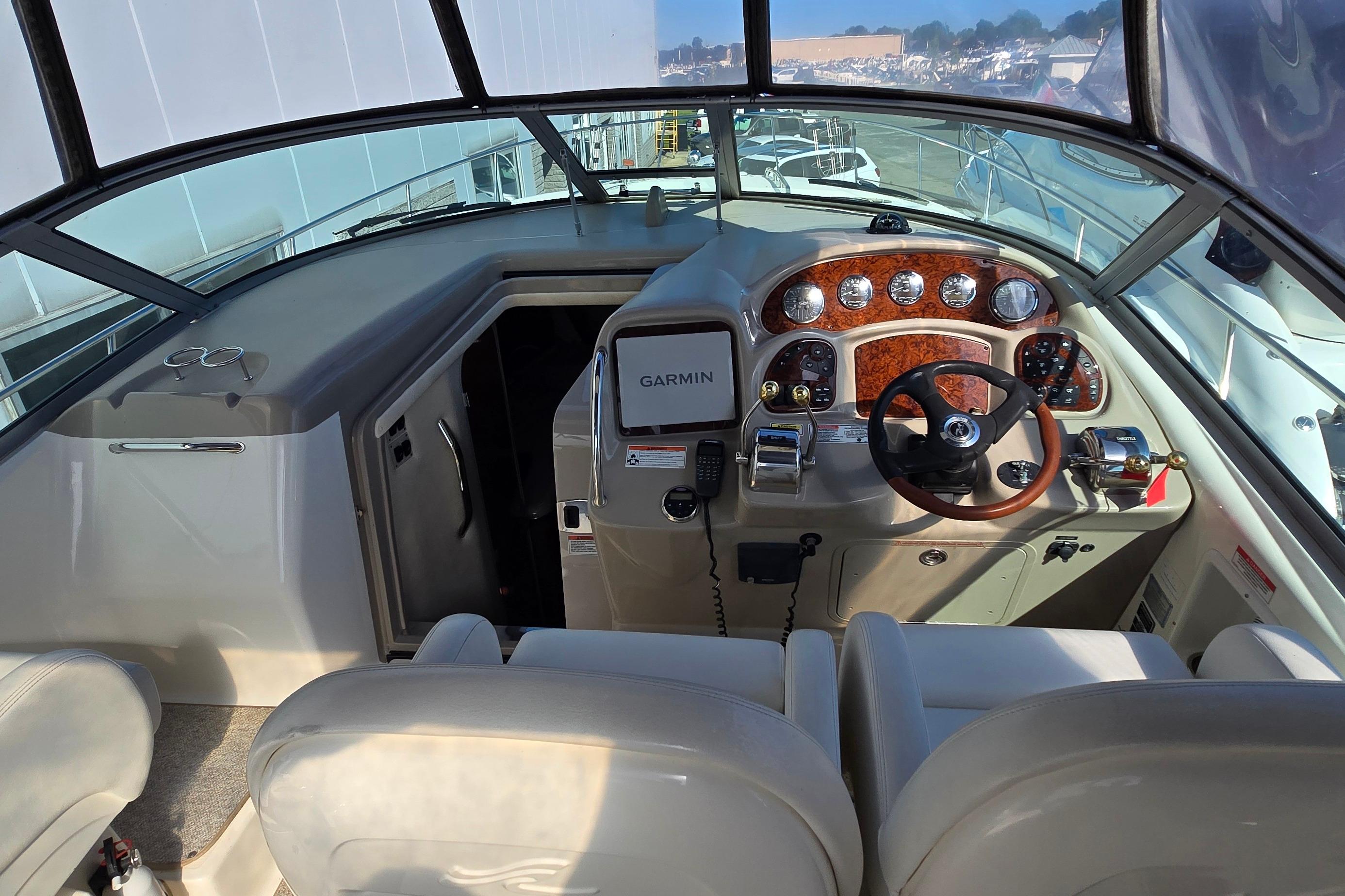 2007 Sea Ray 340 Sundancer helm with Garmin navigation, wood accents, and dual seating.