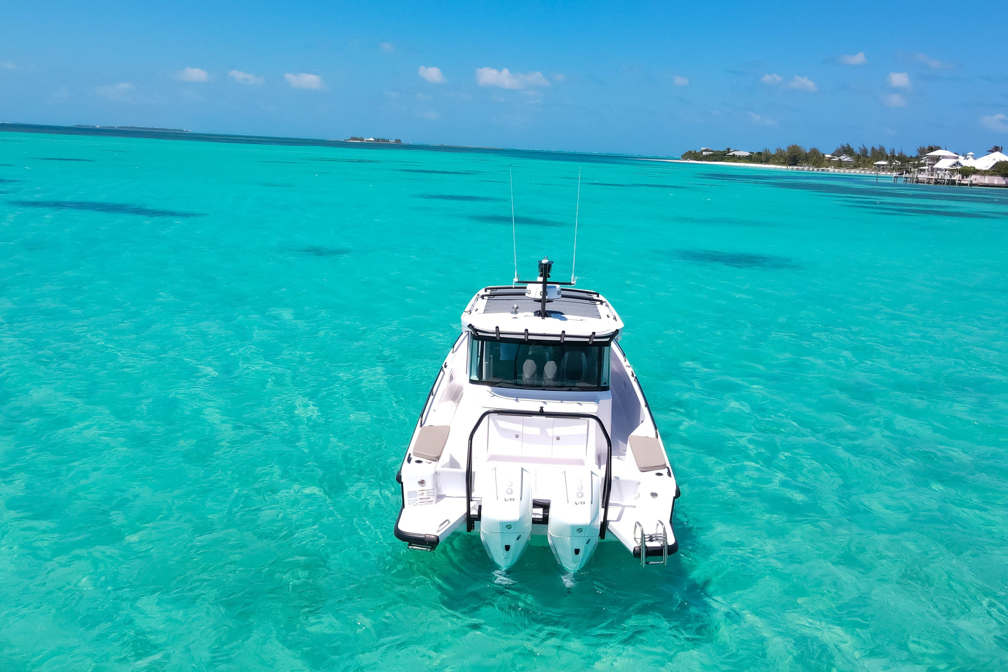 2025 Axopar 37 XC Cross Cabin on turquoise waters, clear sky background.