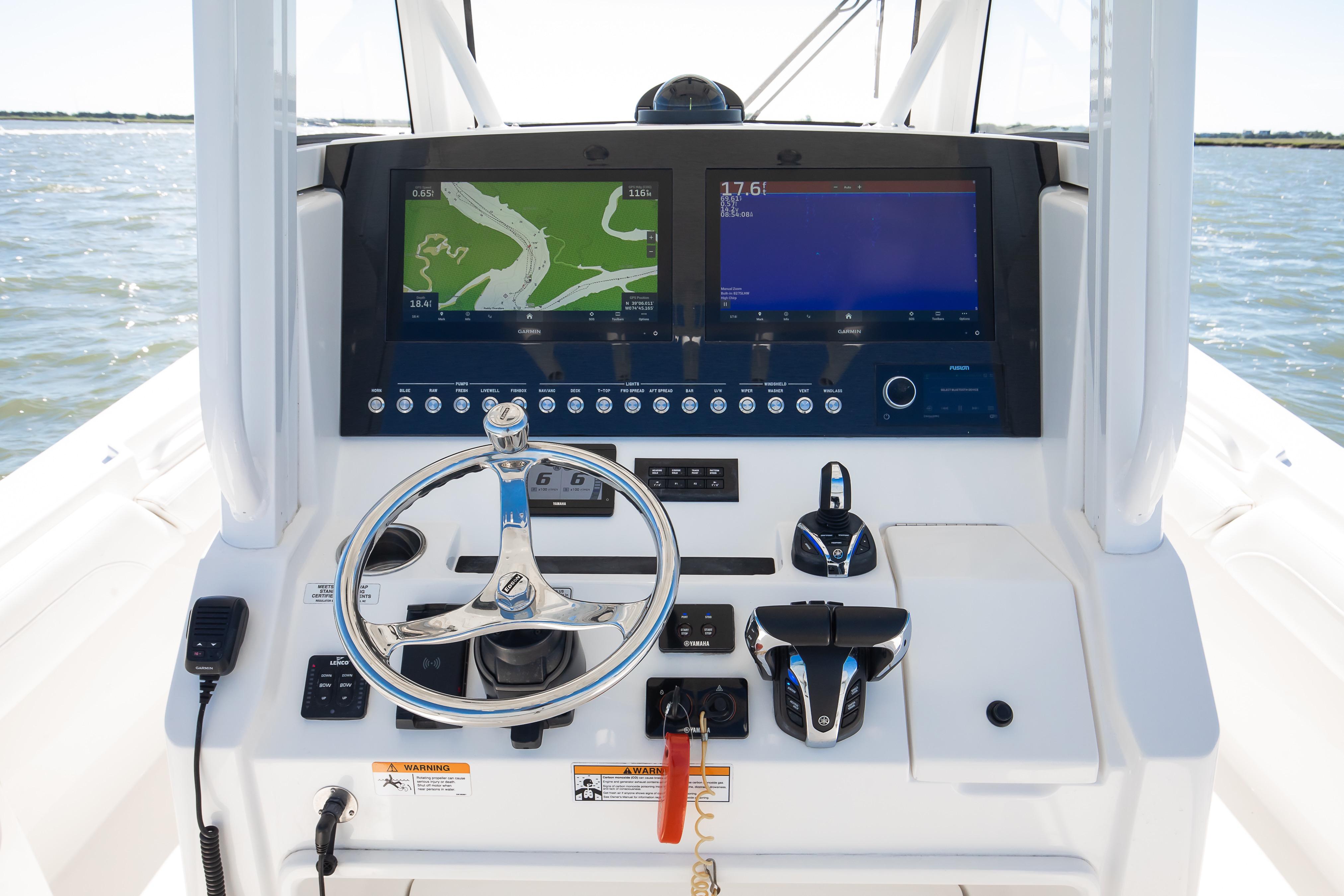 2022 Regulator 28 Forward Seating boat dashboard with dual navigation screens and steering wheel.