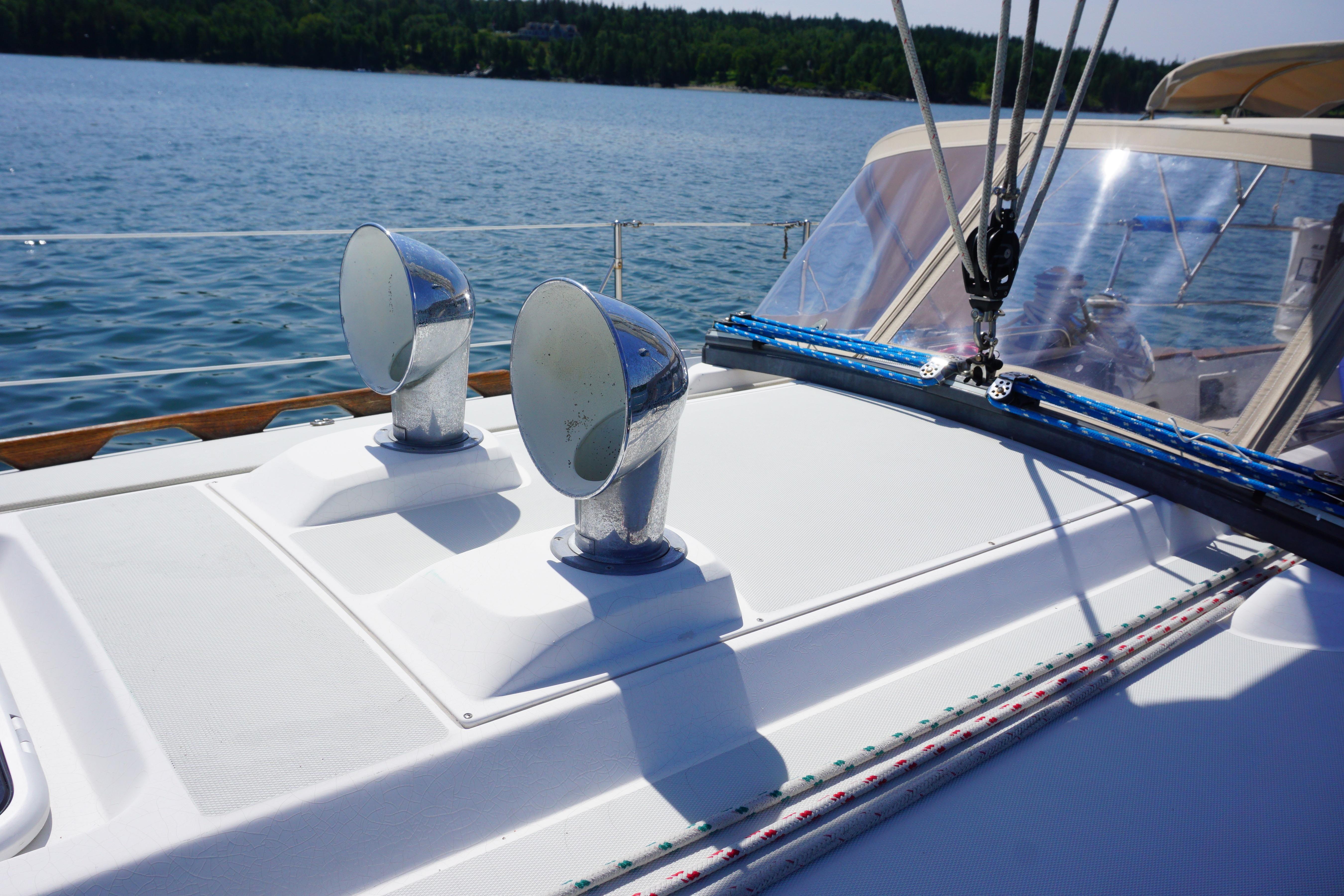 1998 Sabre 402 sailboat deck with chrome vents, ropes, and clear blue water background.