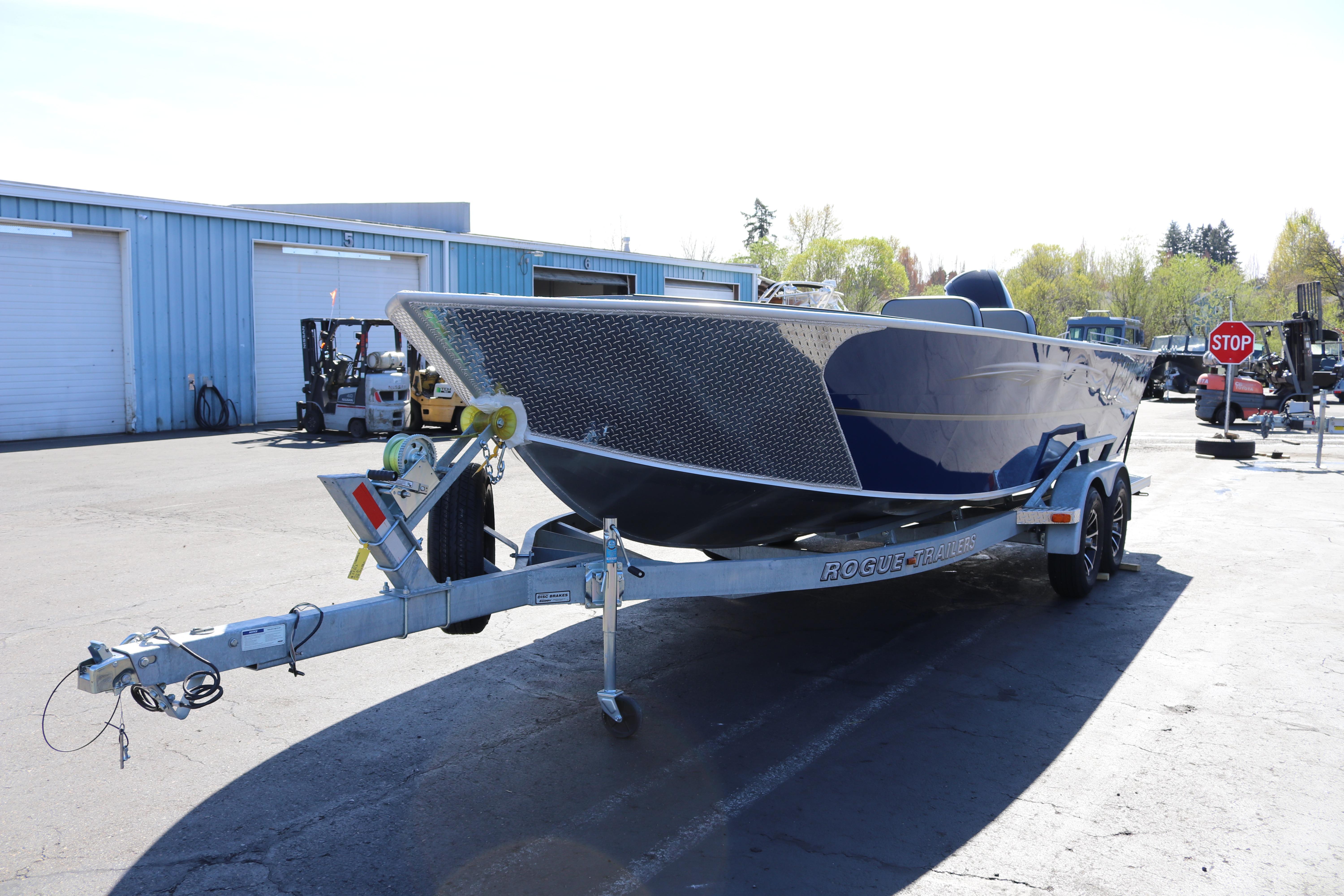 2026 Alumaweld Columbia 21 boat on trailer in parking lot.