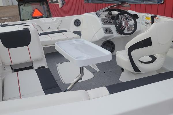 2024 Tahoe 1950 boat interior with white and black seating, steering console, and table.