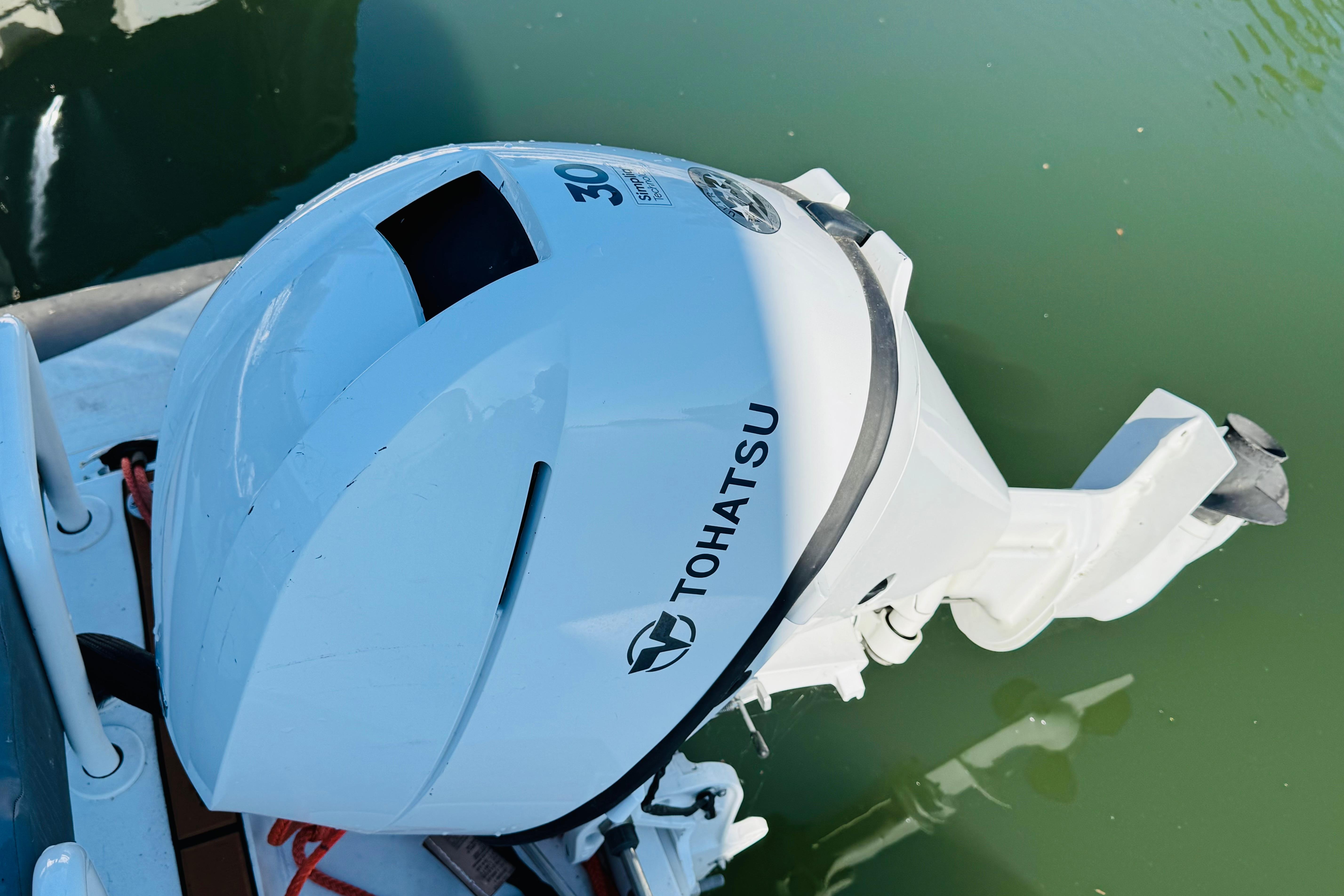 Tohatsu outboard motor on a 1996 Nordic Tug 32, docked on calm water.
