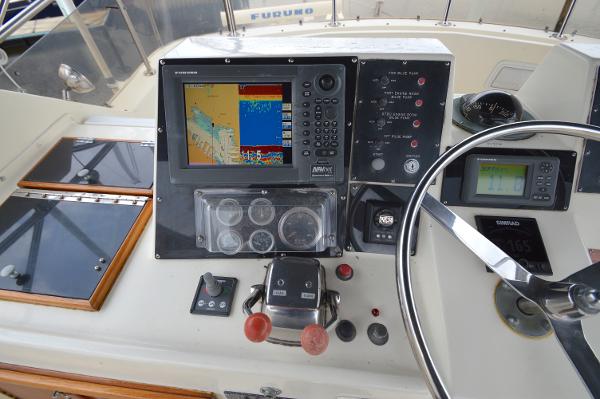 The image shows the helm of a 1980 Hatteras 53 Yacht Fisherman with navigation equipment.