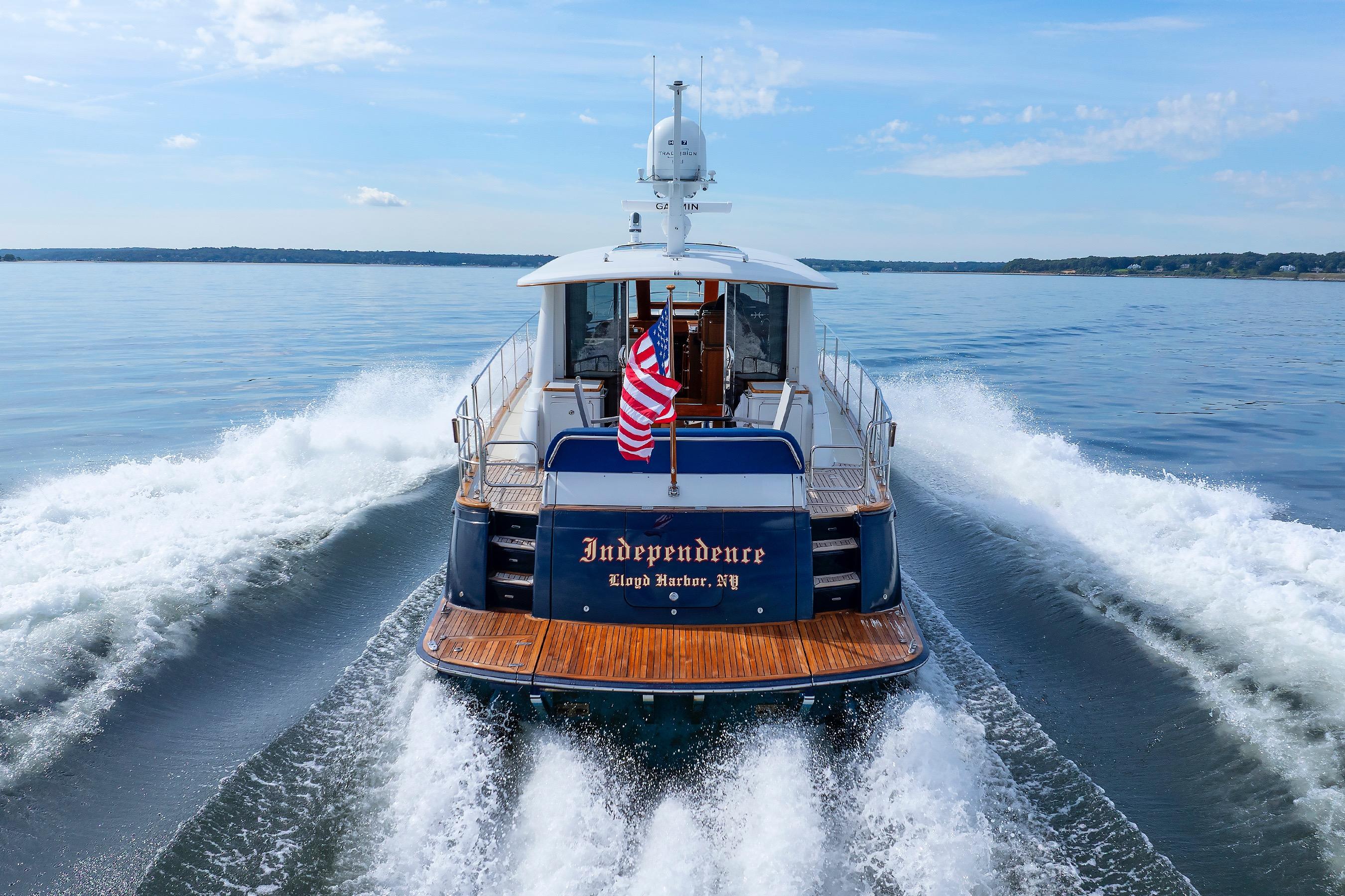 2009 Hunt Yachts 52 Express cruising on open water, rear view with American flag.
