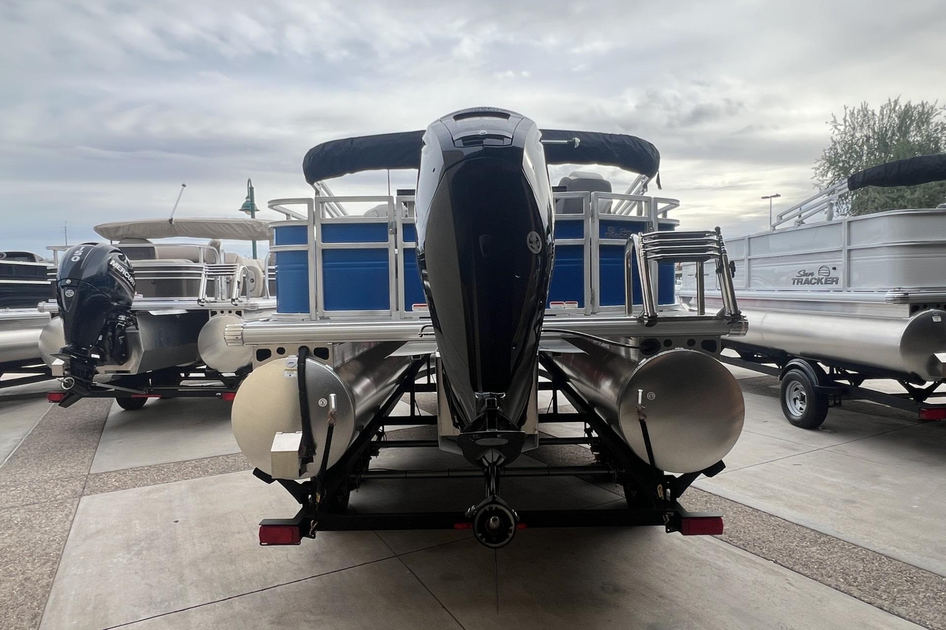 2026 Sun Tracker Fishin' Barge 20 DLX pontoon boat with outboard motor, rear view.