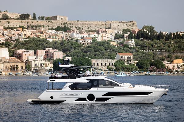 Aicon Vivere 68 yacht cruising near a scenic coastal town, 2025 model.