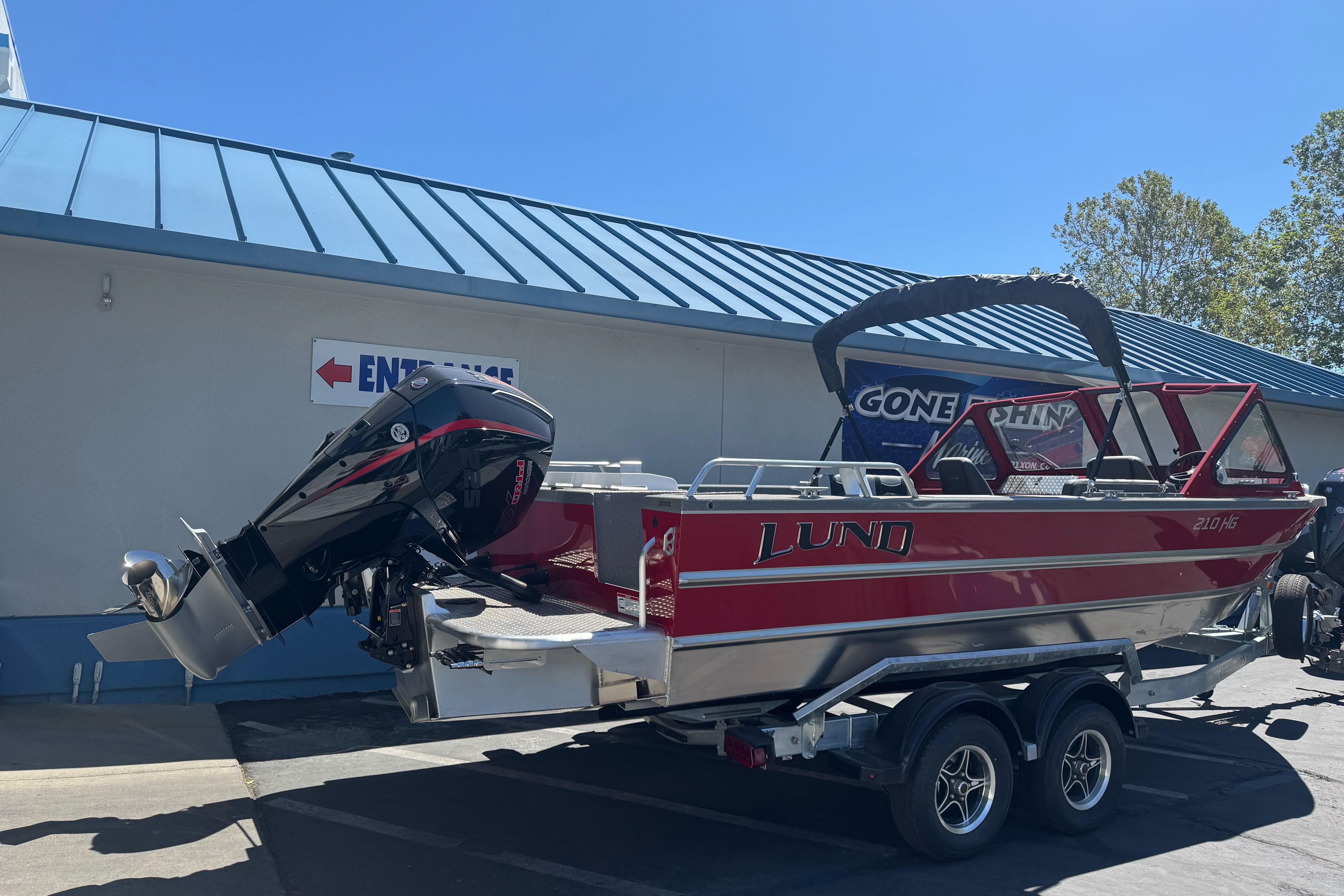 2026 Lund 210 Heavy Gauge boat on trailer, parked outside a building.