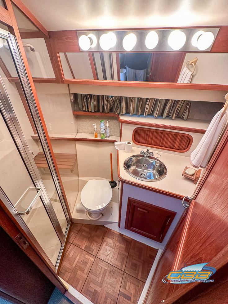 1989 Carver 3807 Aft Cabin bathroom with shower, sink, and wood accents.