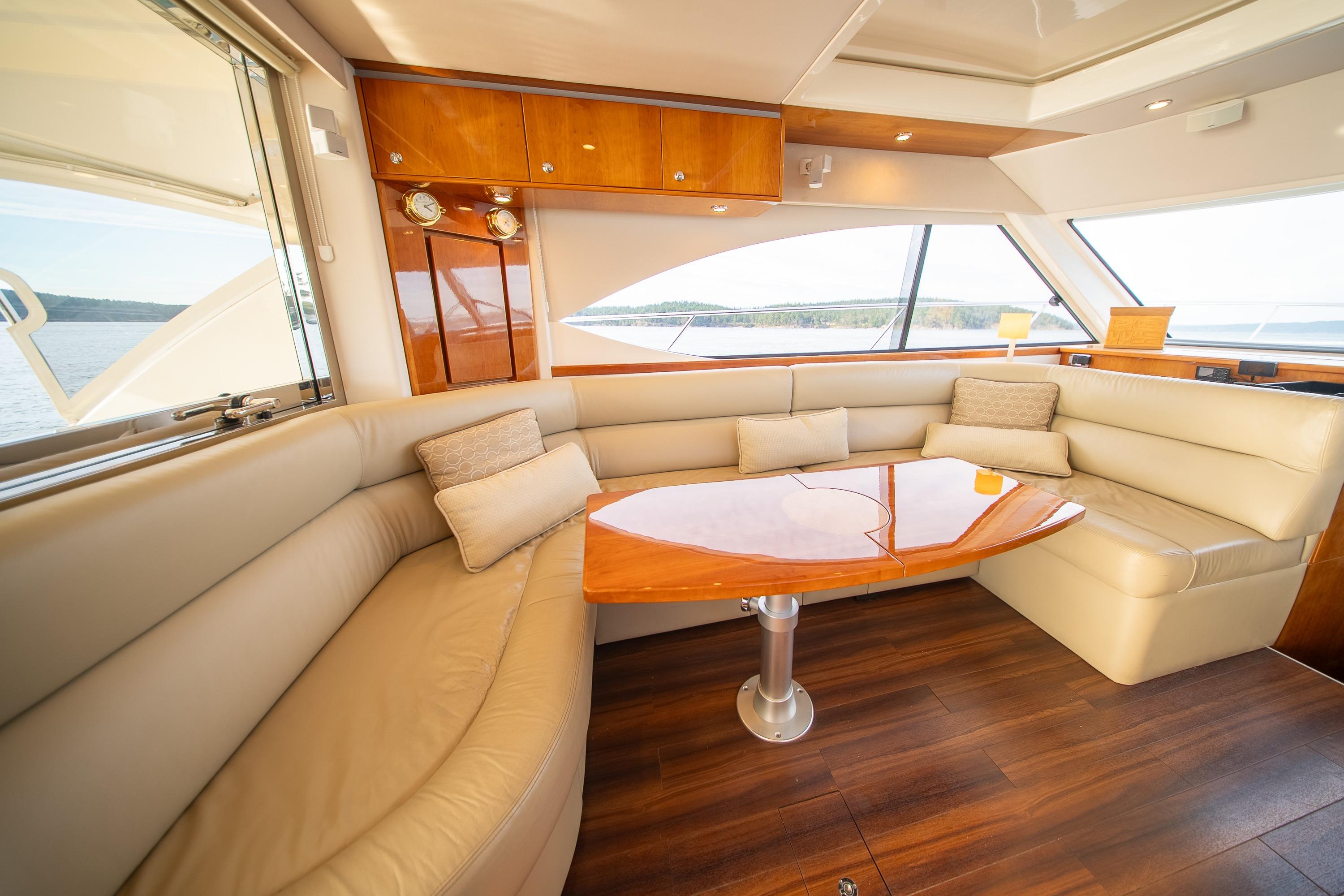 Luxurious interior of 2011 Riviera 5000 Sport Yacht with plush seating and elegant wood finishes.