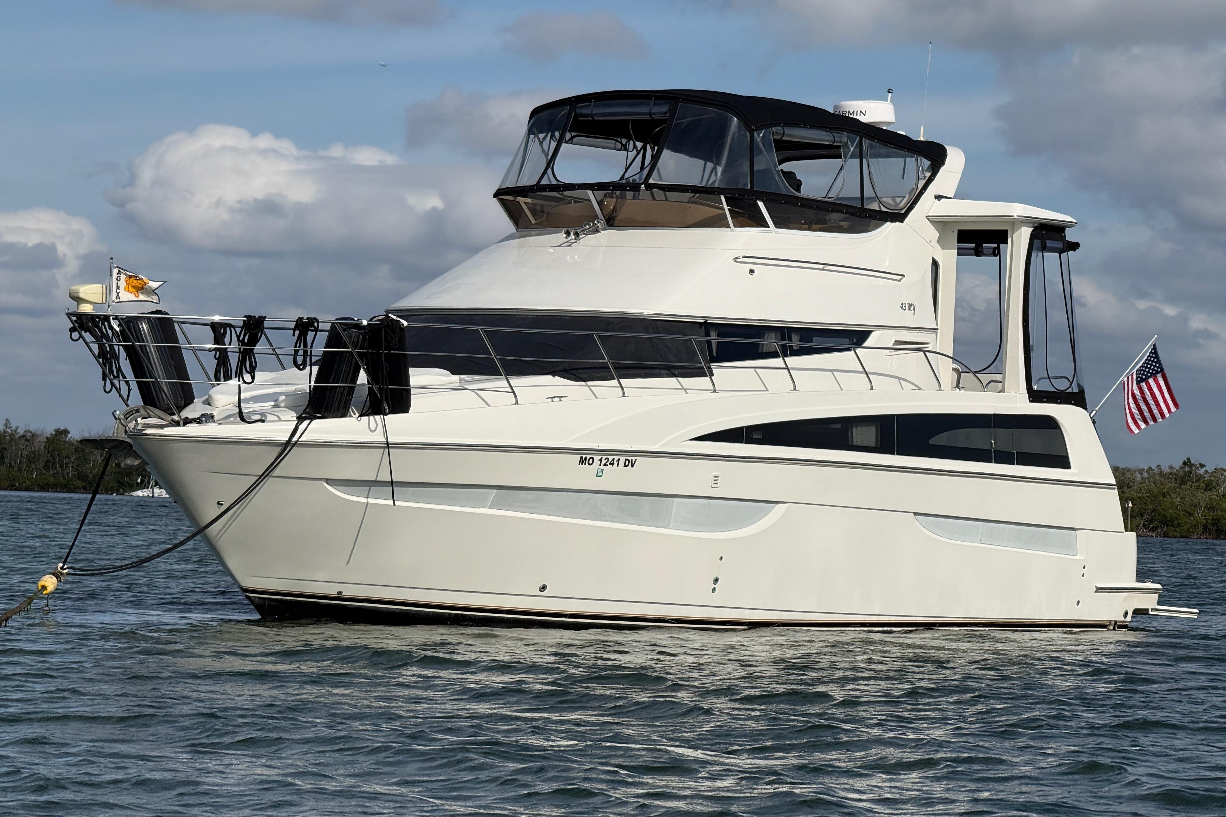 2006 Carver 43 Motor Yacht anchored on calm water with American flag.