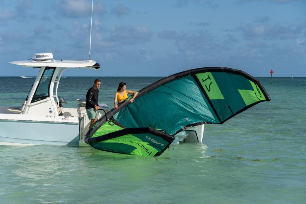 2024 Boston Whaler 280 Dauntless with people preparing a kiteboard in shallow water.