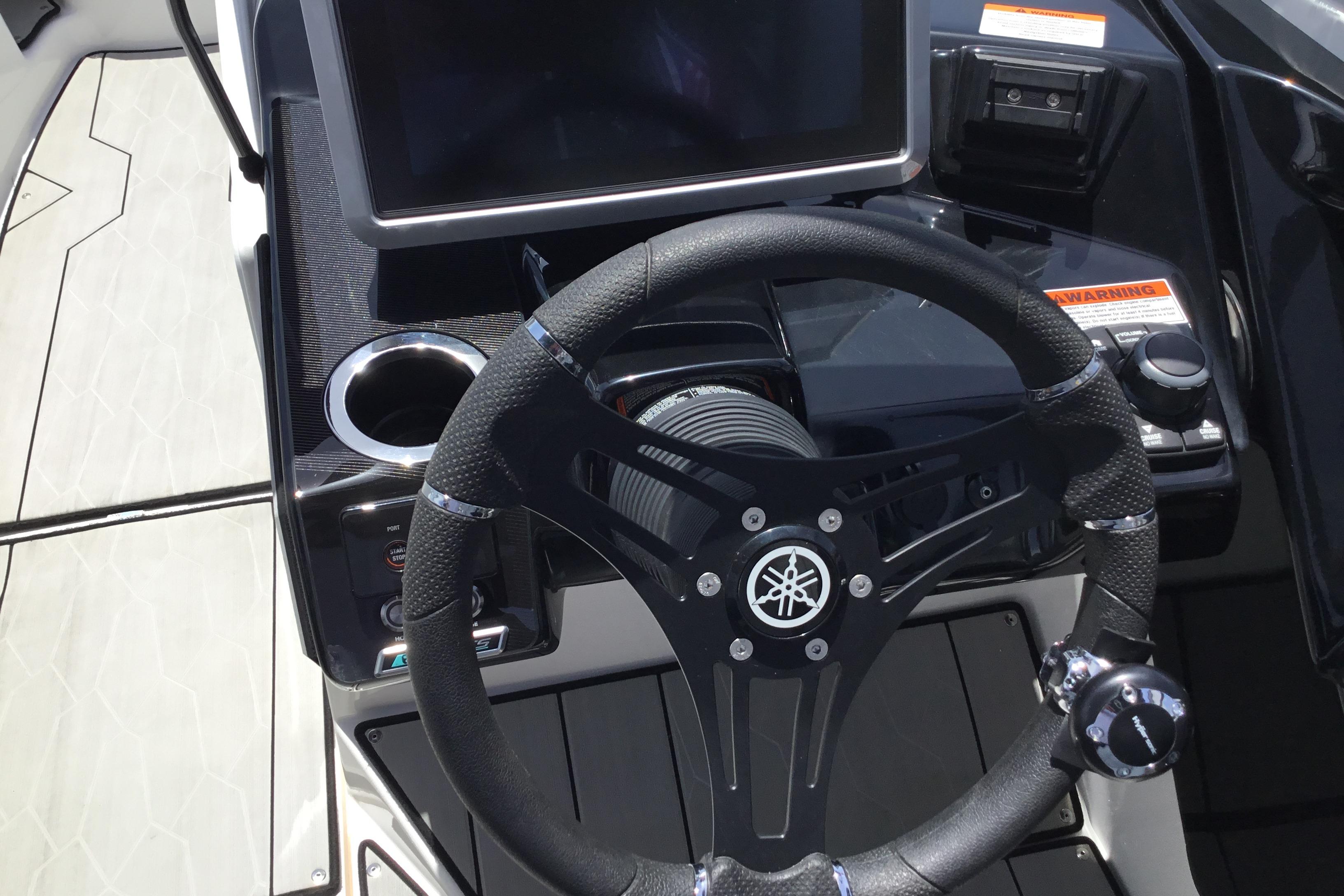 2023 Yamaha Boats 252XE steering wheel and dashboard with modern controls and display.