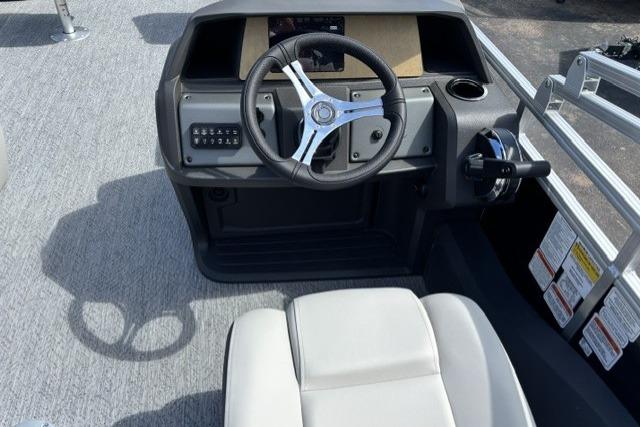 2026 Sun Tracker Fishin' Barge 22 DLX helm with steering wheel and controls.