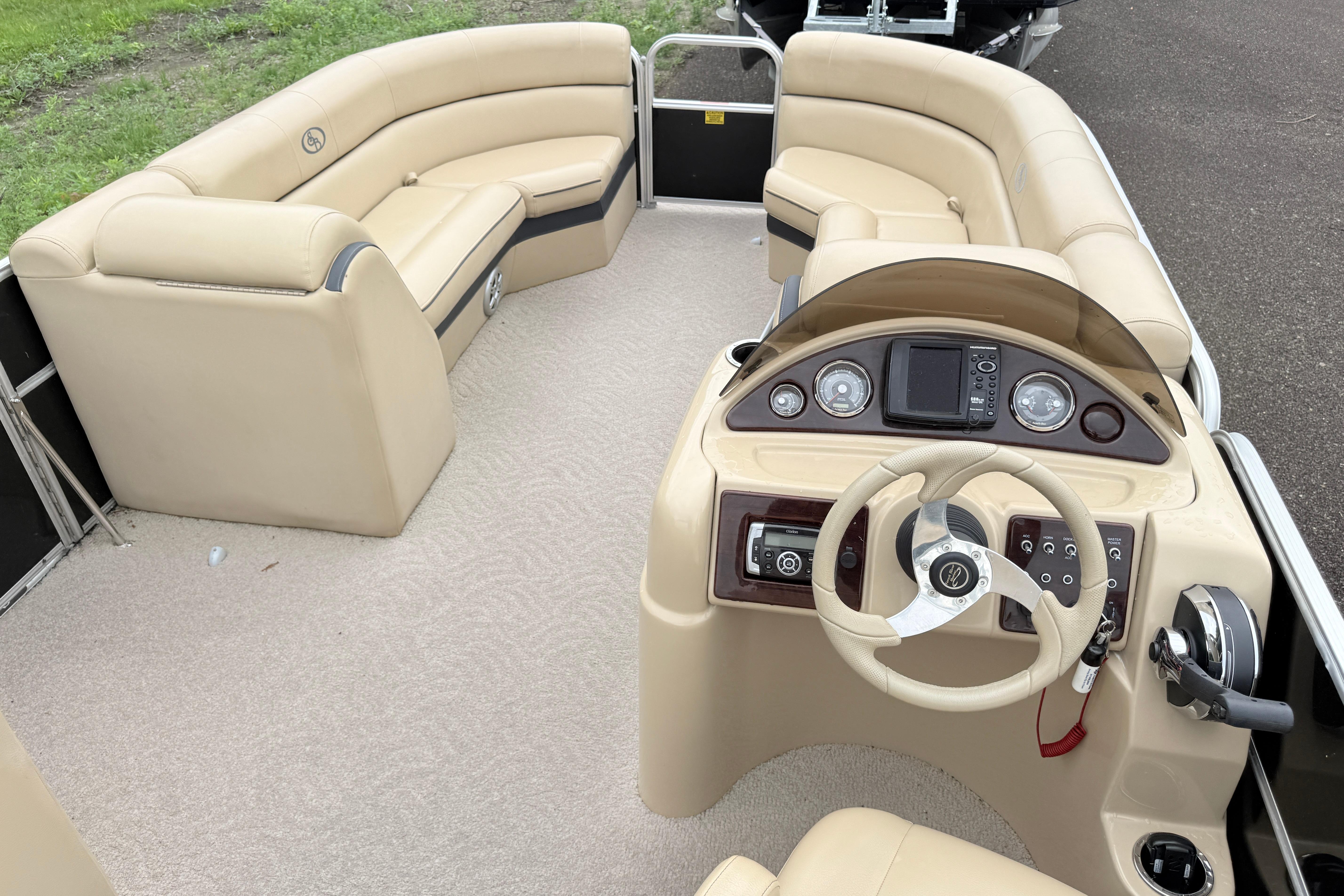2013 South Bay 522CR pontoon boat interior with beige seating and modern dashboard.