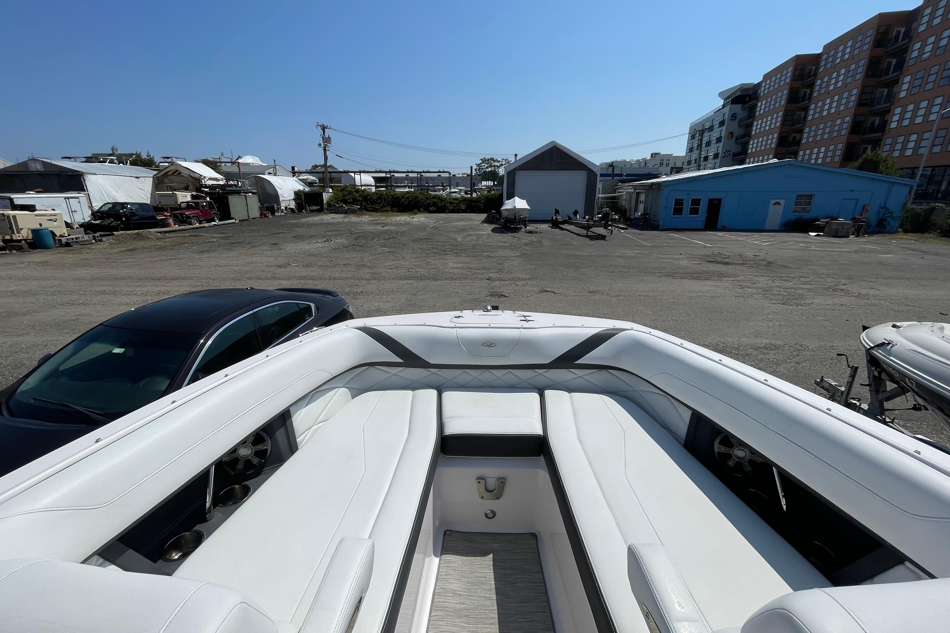 2018 Regal 26 OBX boat with white seating, parked in a marina lot.