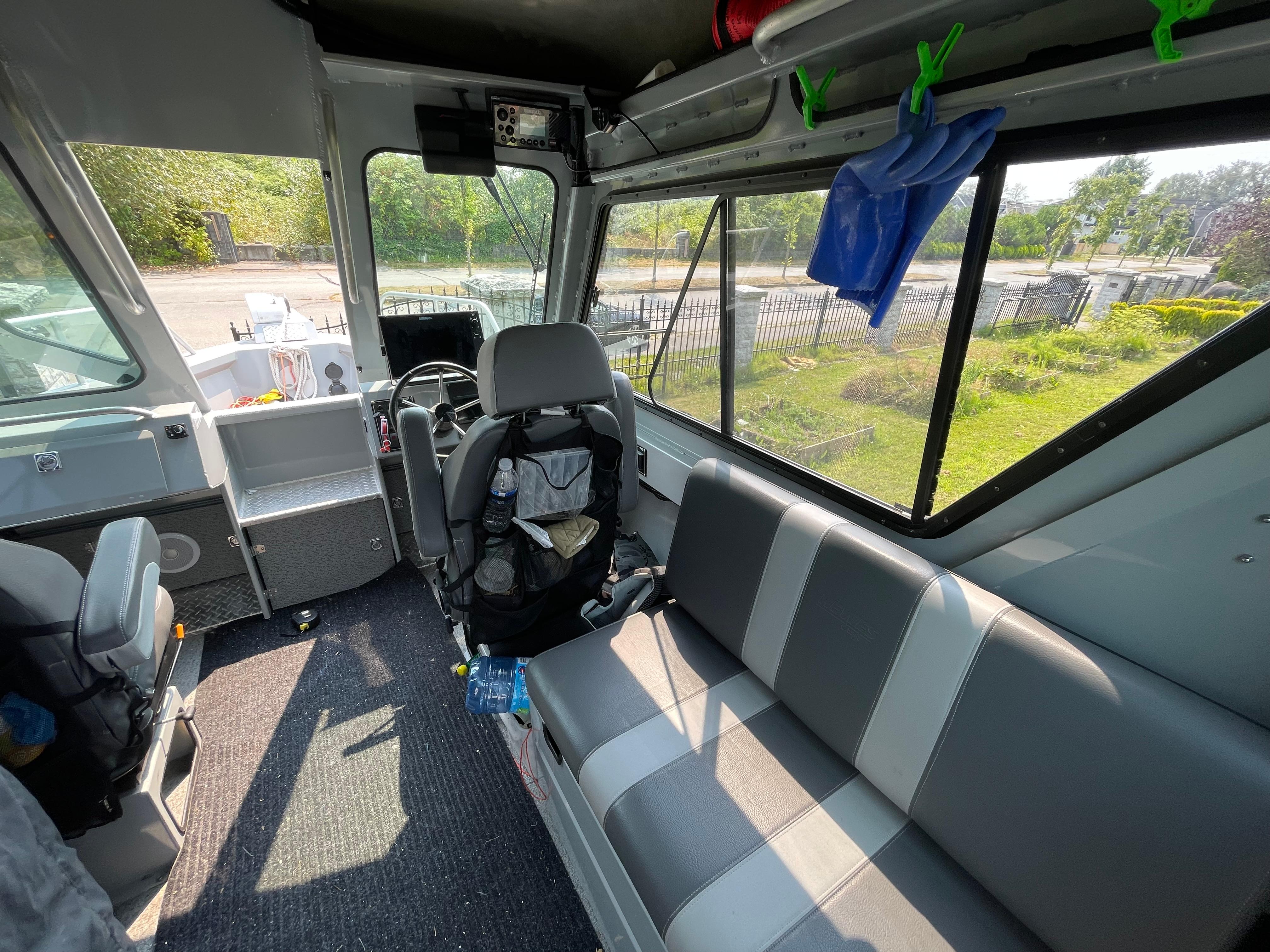 Interior of 2022 Hewescraft 240 Ocean Pro ET HT boat with seating and windows.